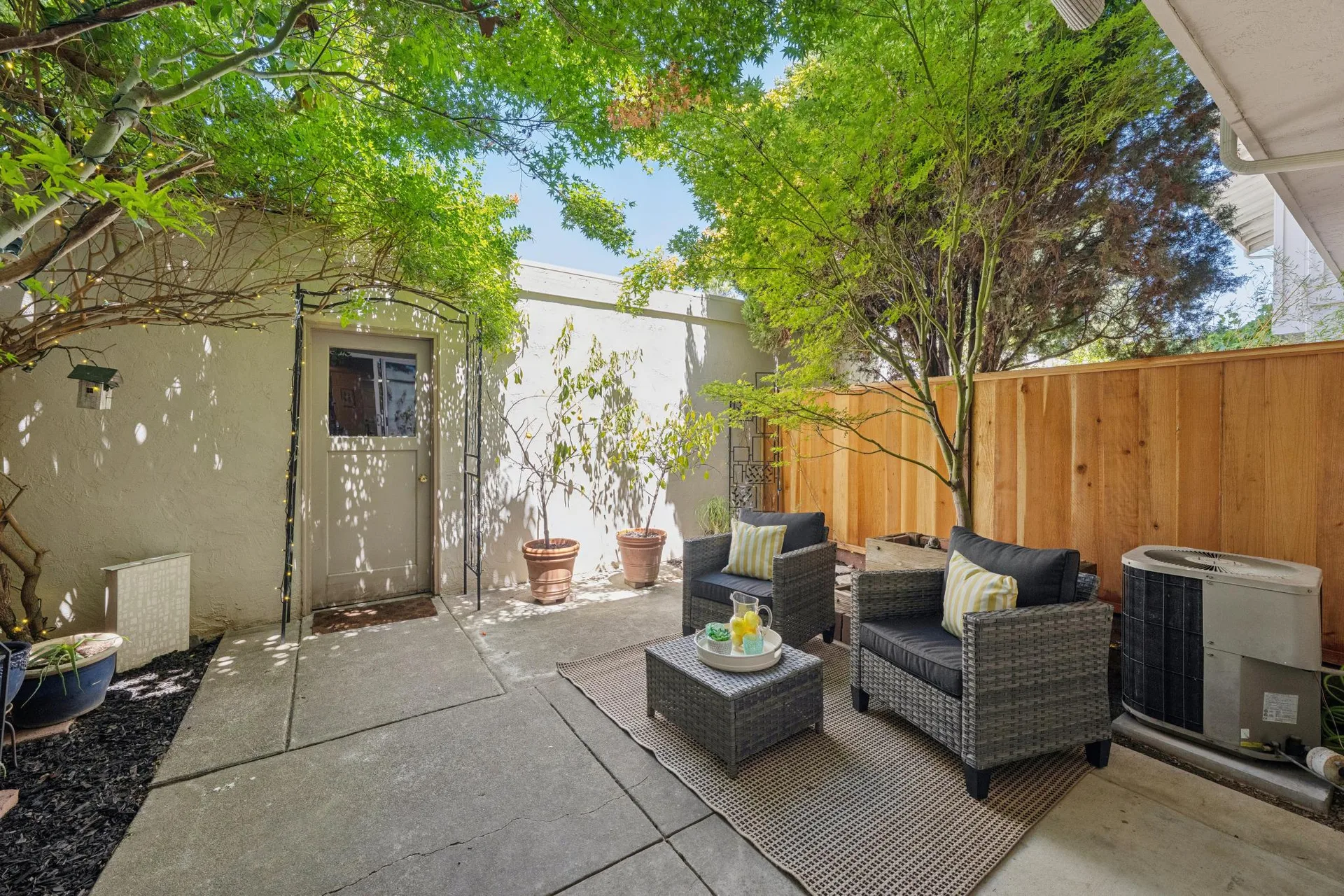 Private patio with mature trees and outdoor seating