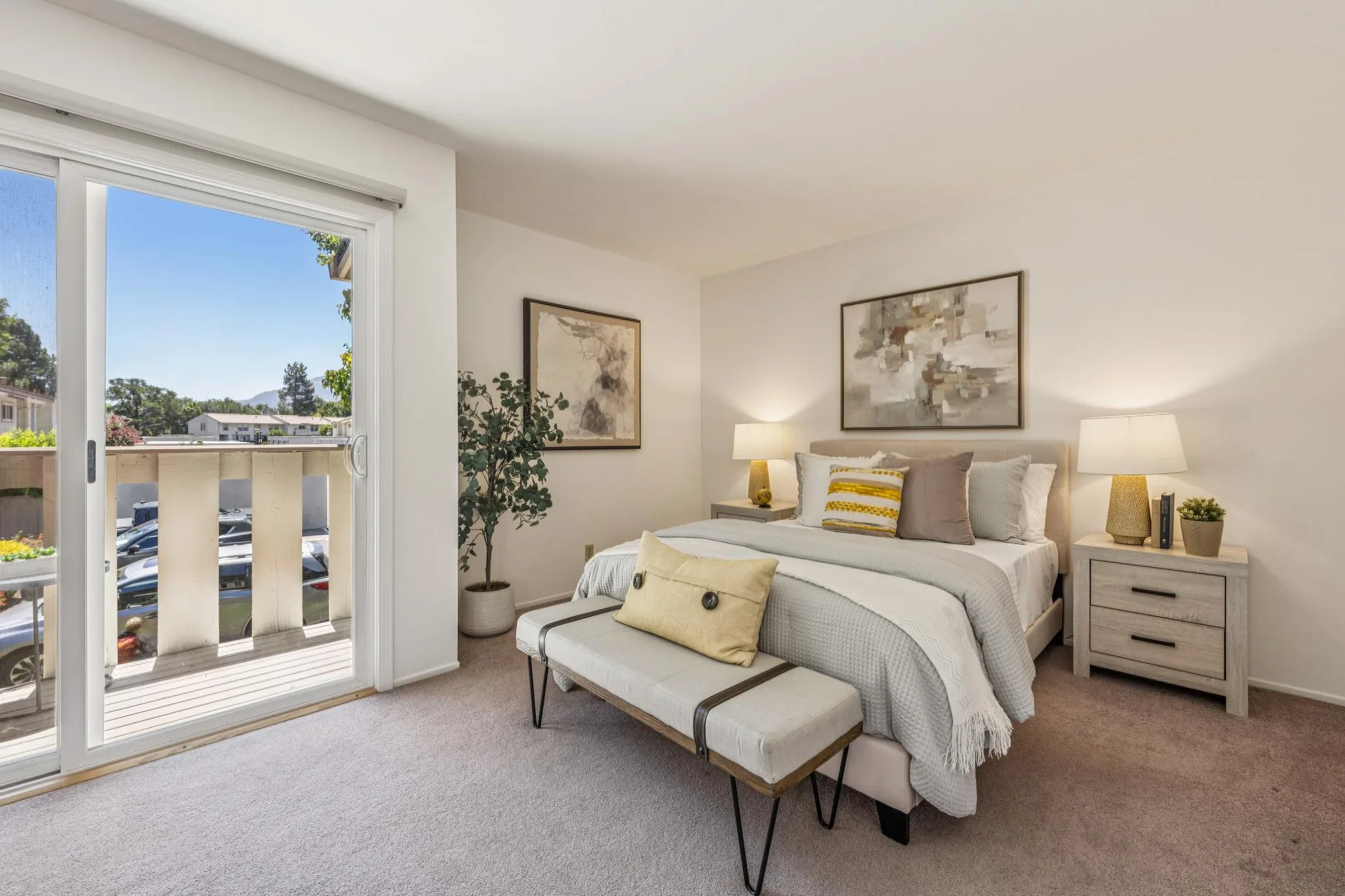 Bedroom with sliding glass door providing balcony access, bench, and natural light