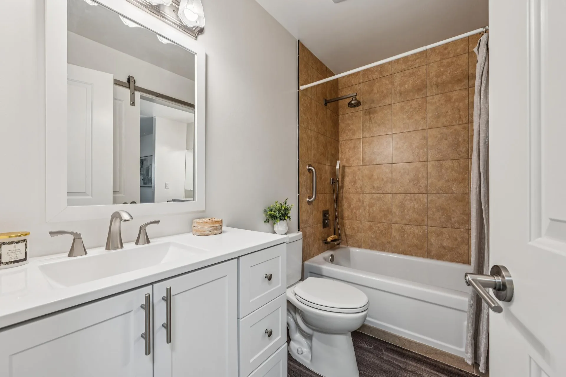 Updated full bathroom with white vanity and tile tub surround