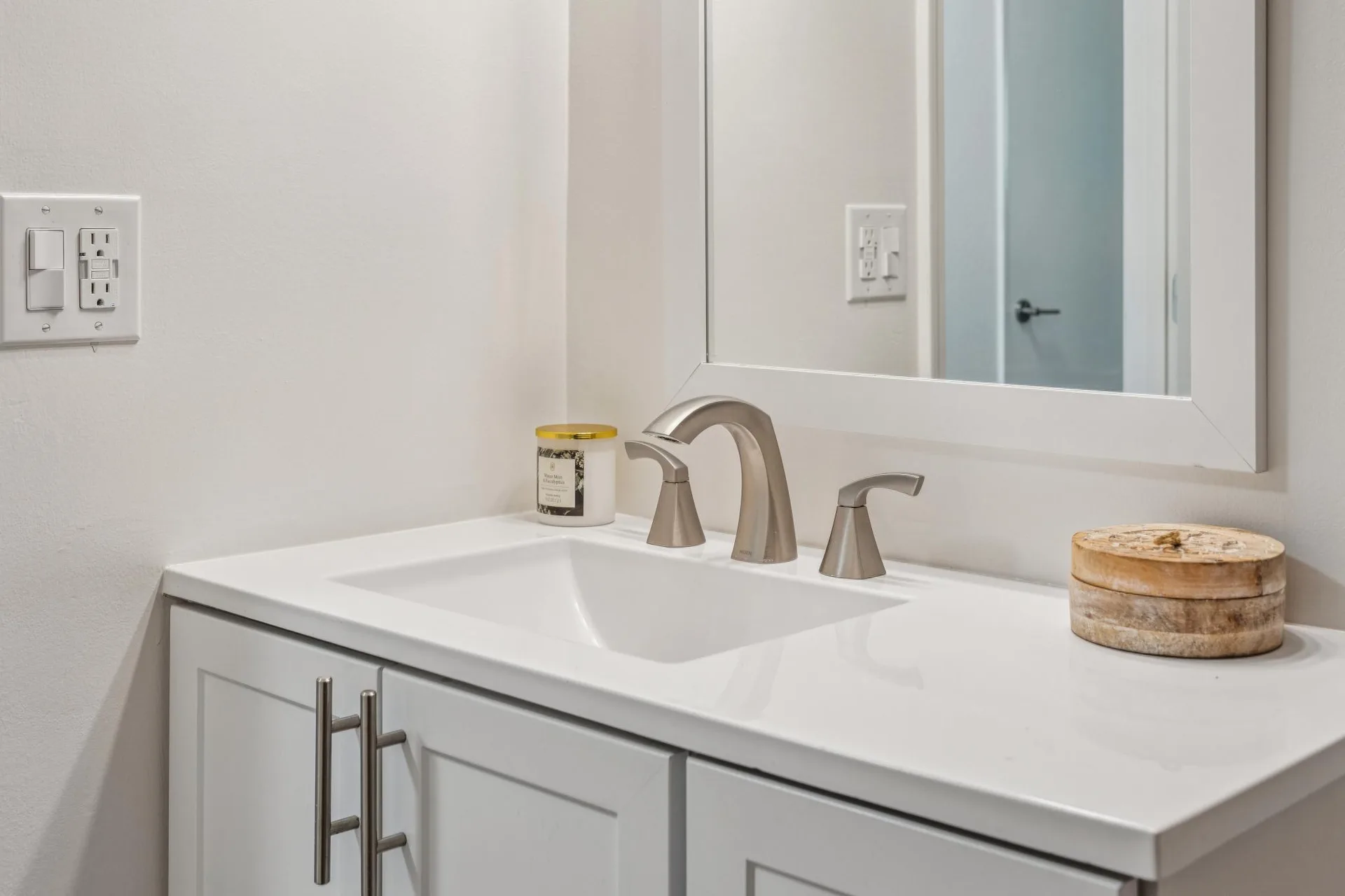 Bathroom vanity with white quartz countertop and brushed nickel faucet