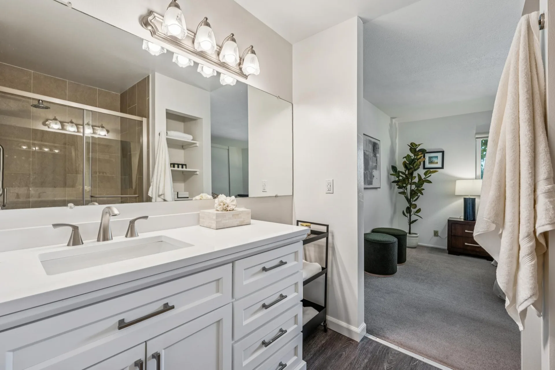Bathroom vanity looking into the bedroom with framed mirror and quartz countertop