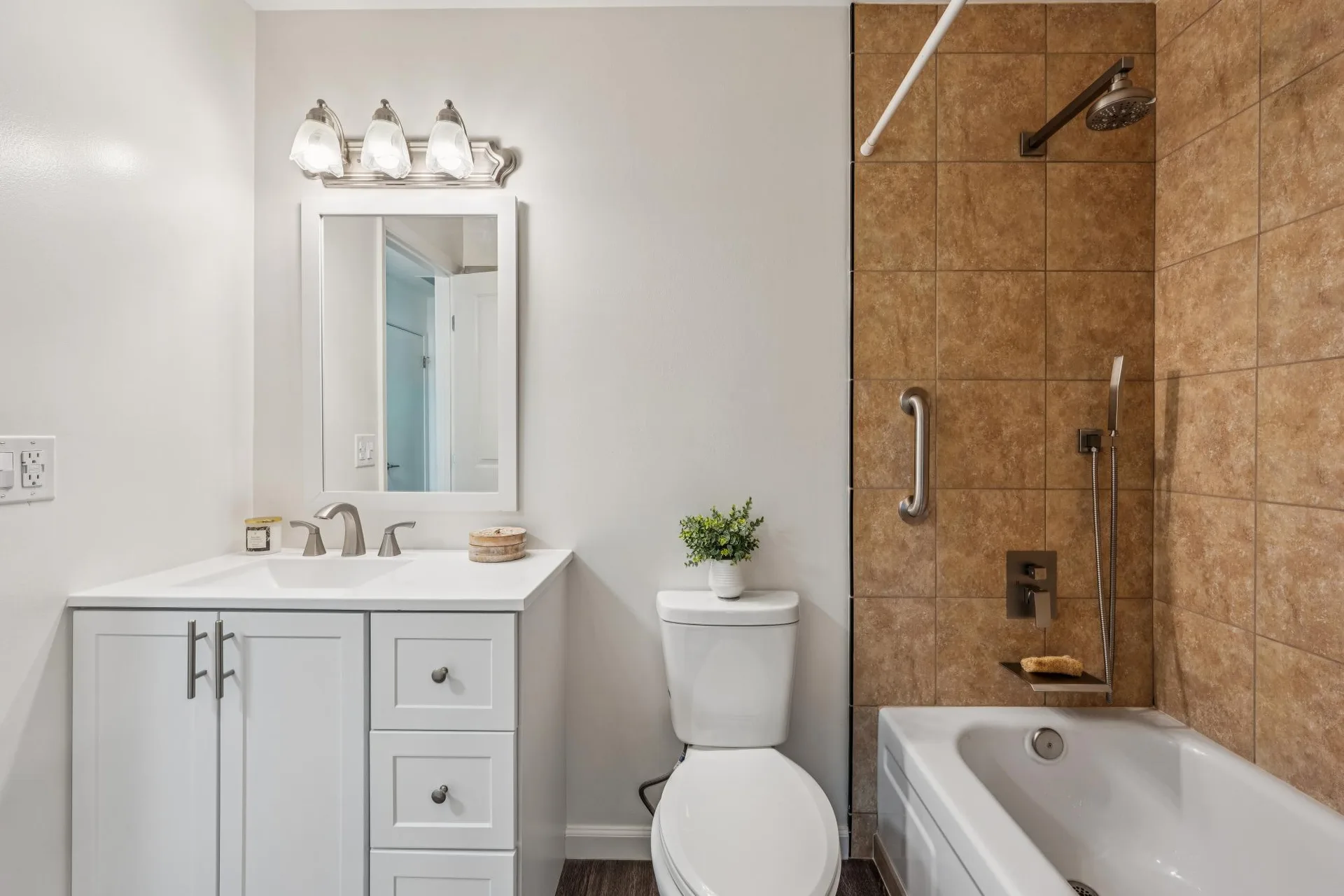 Full bathroom with white shaker vanity, tan tile shower, and tub combo