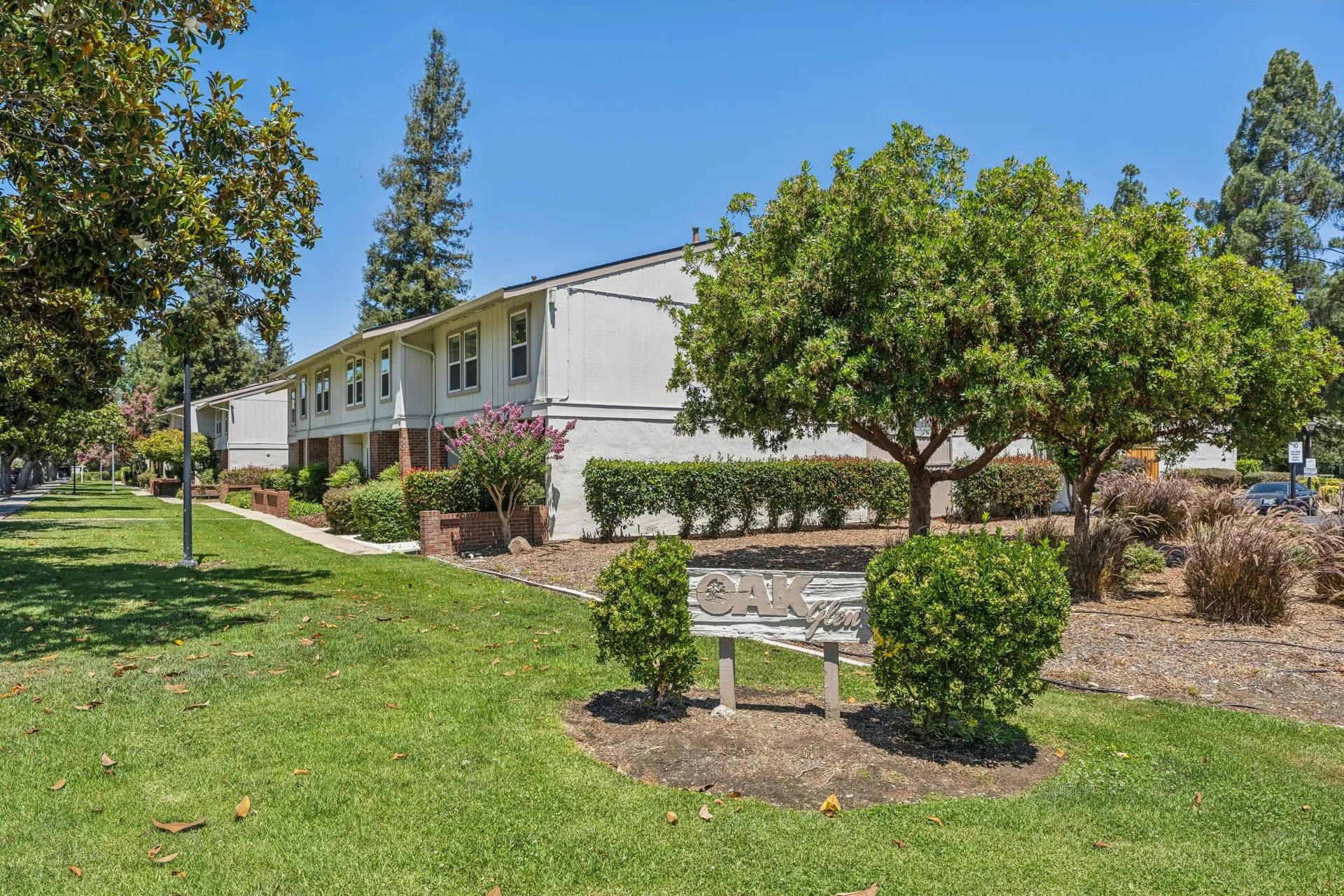 Oak Glen community entrance with monument sign, mature trees, and landscaping
