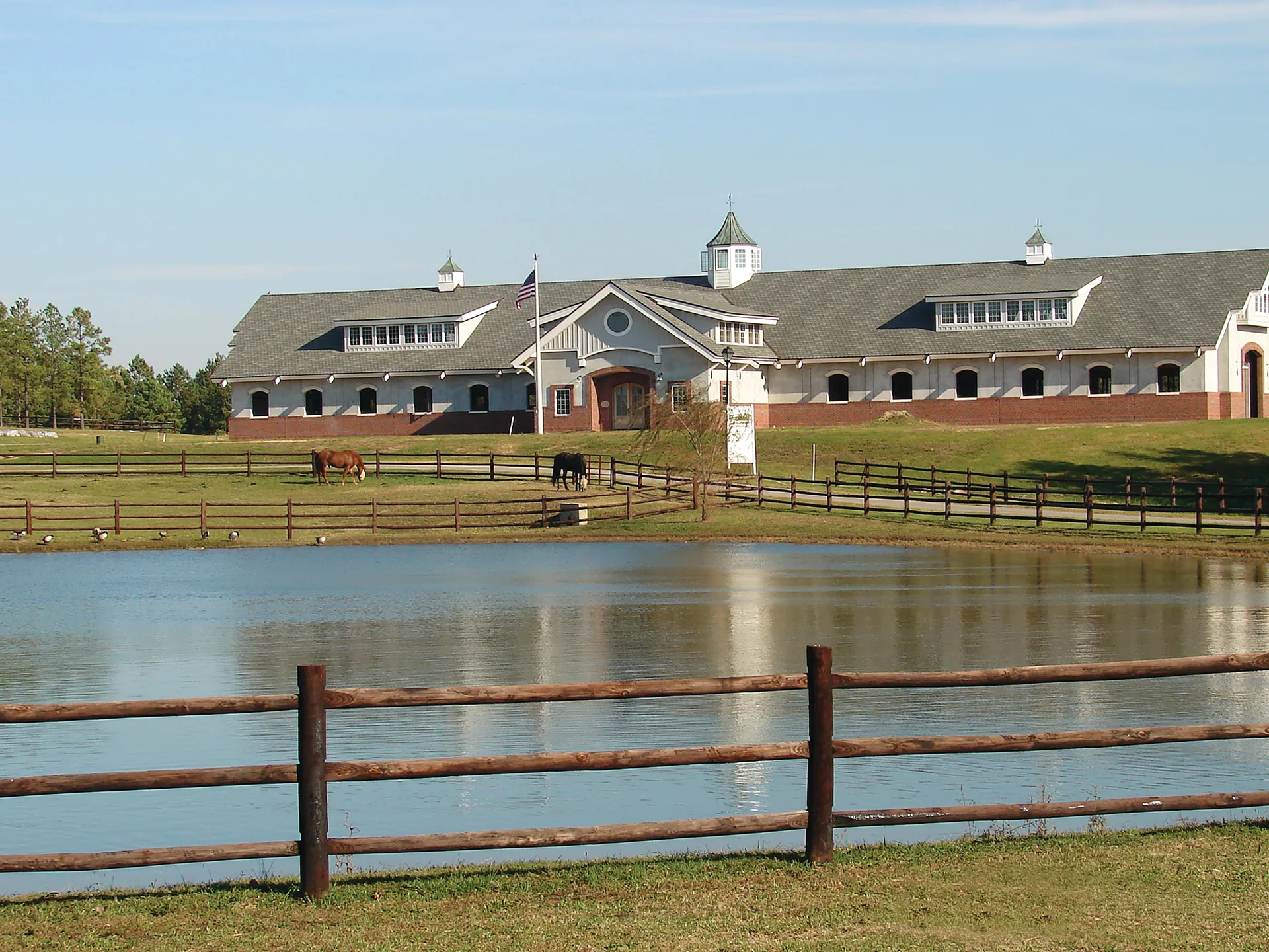 Portofino community pond with equestrian facility and green surroundings