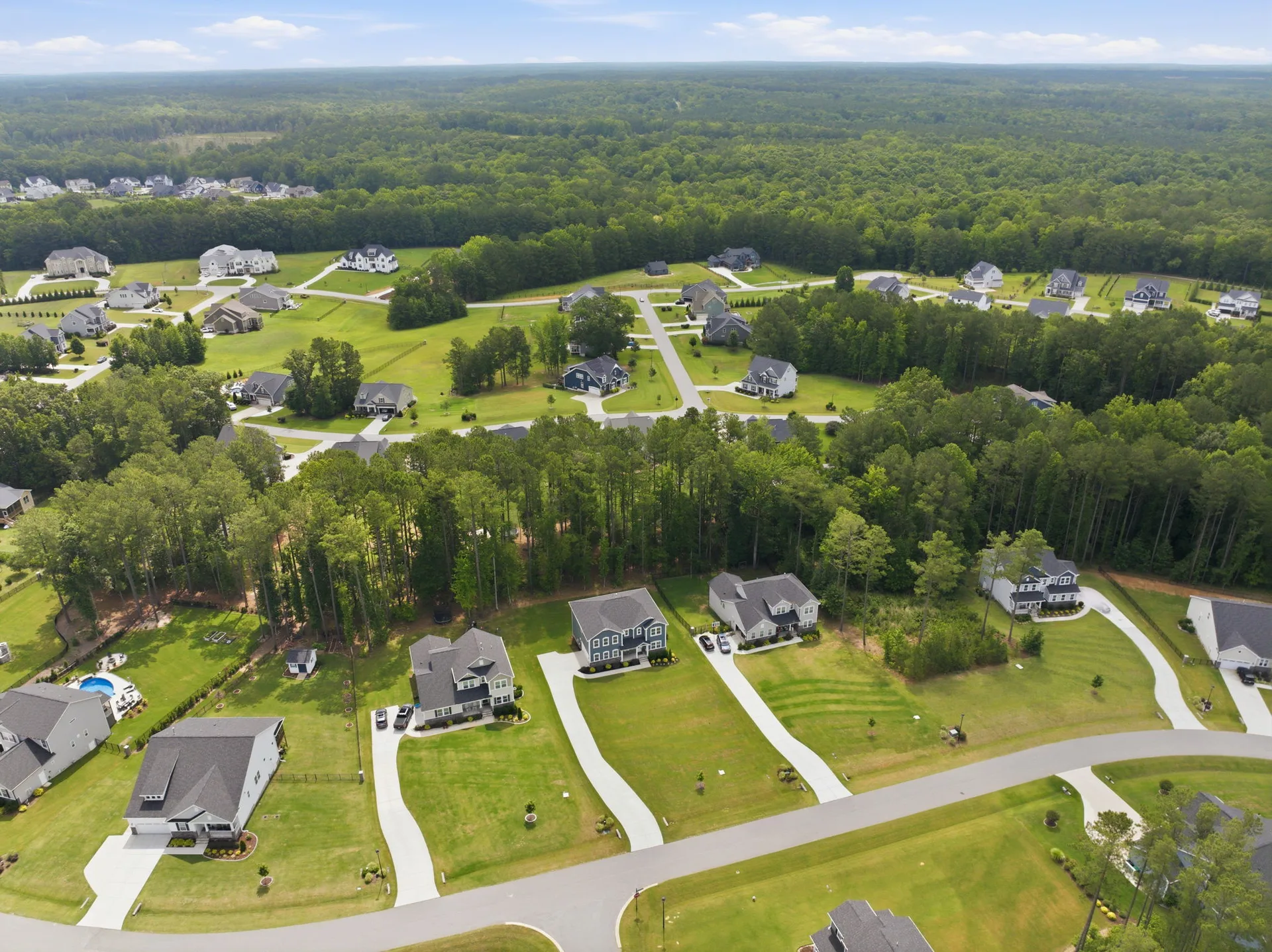 Drone aerial overview of the Portofino community in Clayton NC showing homes nestled among mature trees