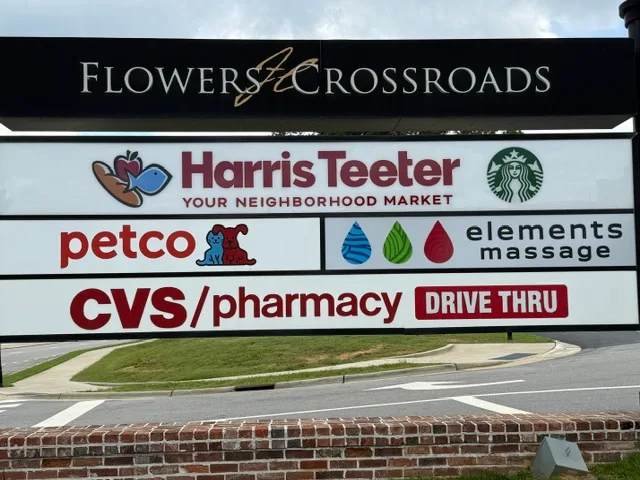Flowers Crossroads shopping center signage showing Harris Teeter, Petco, Elements Massage, and CVS