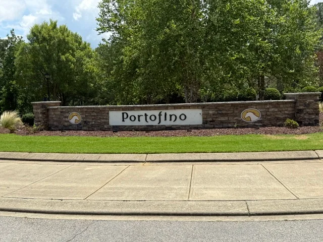 Portofino community entrance stone wall sign with green landscaping and trees