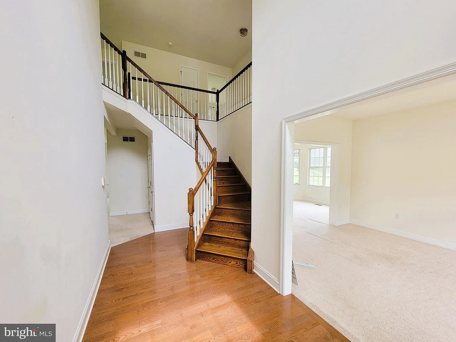 Foyer with hardwood staircase and white railings