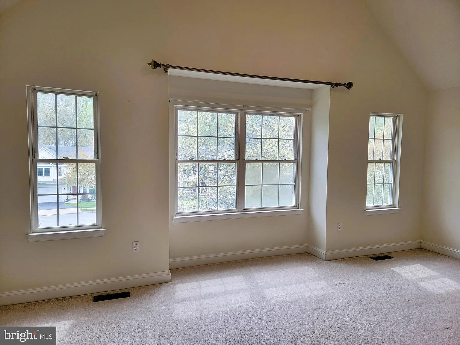 Bedroom with vaulted ceiling and natural light
