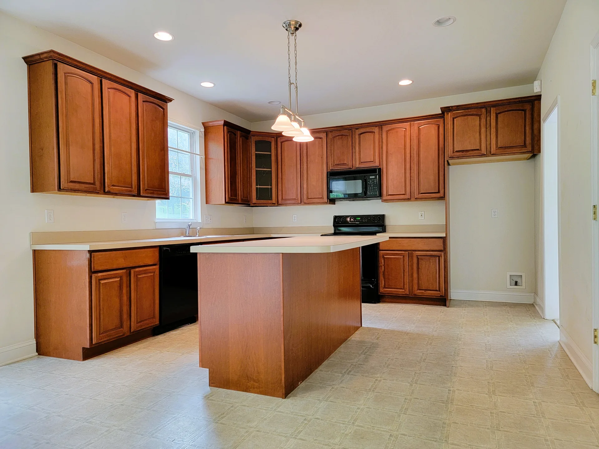 Kitchen with stained wood cabinetry and black appliances