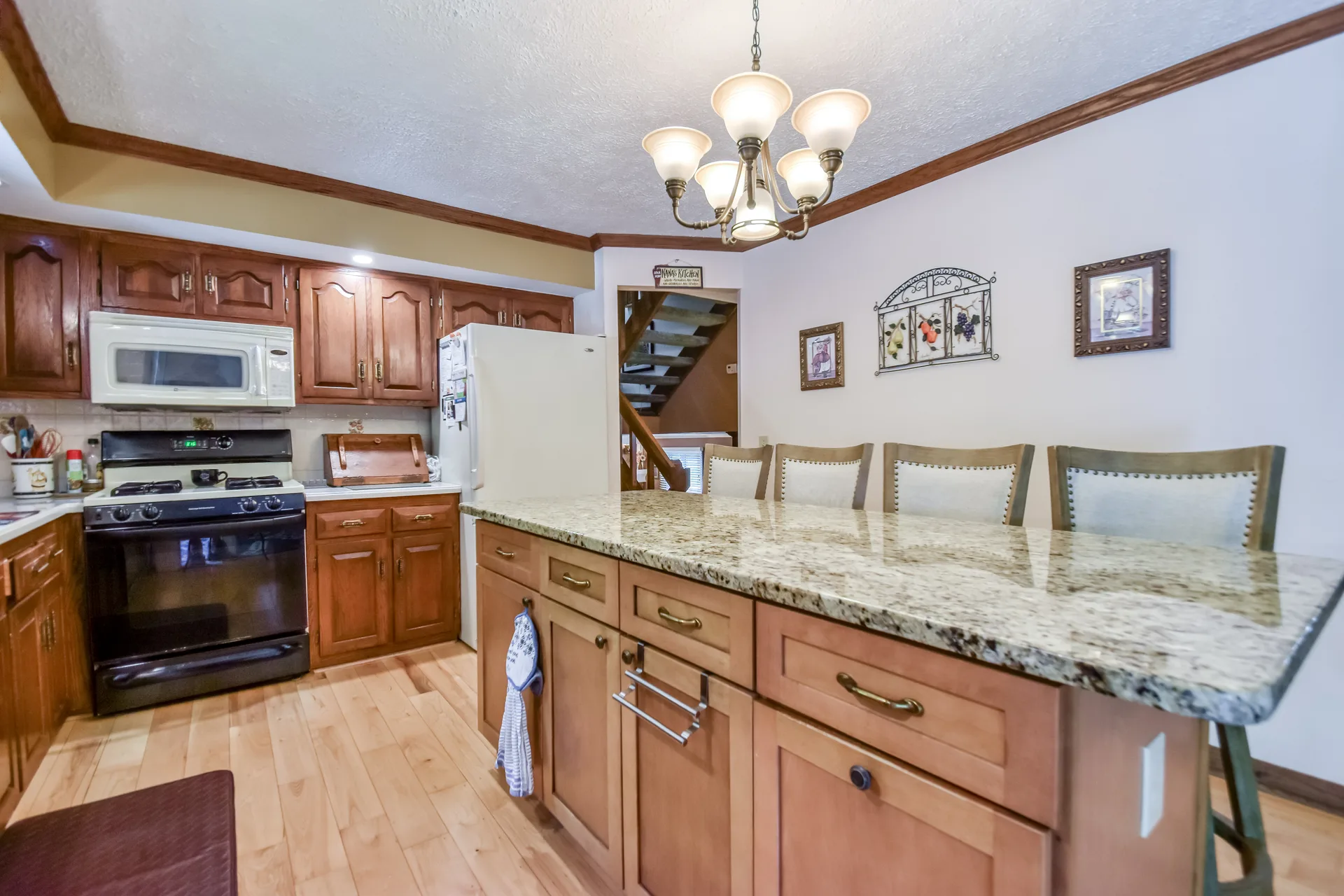 Kitchen wide view with stained oak cabinets and granite countertops