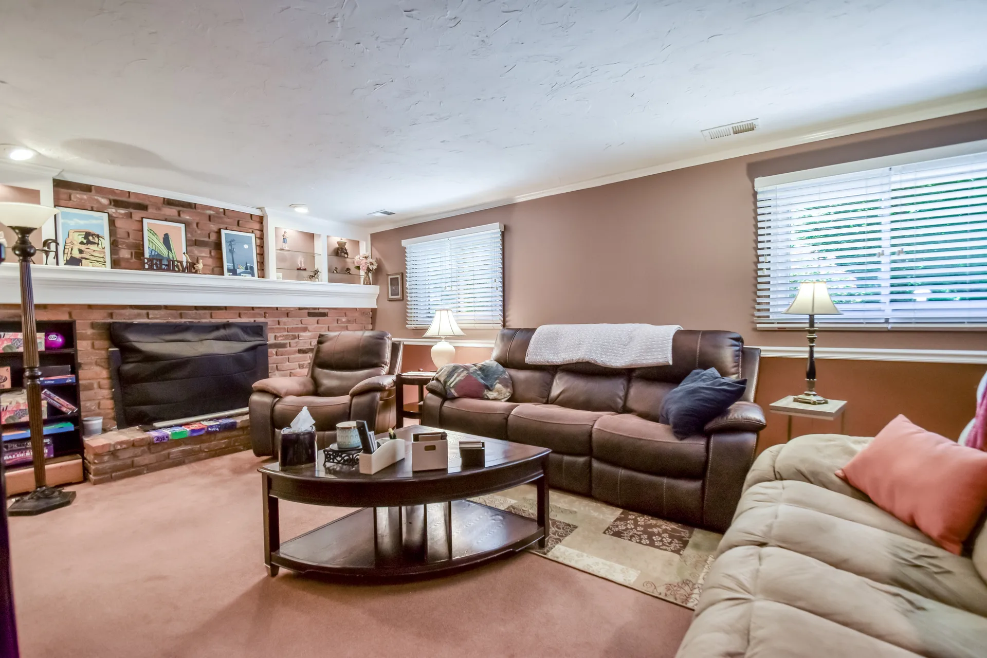 Living room with brick fireplace and built-in shelving