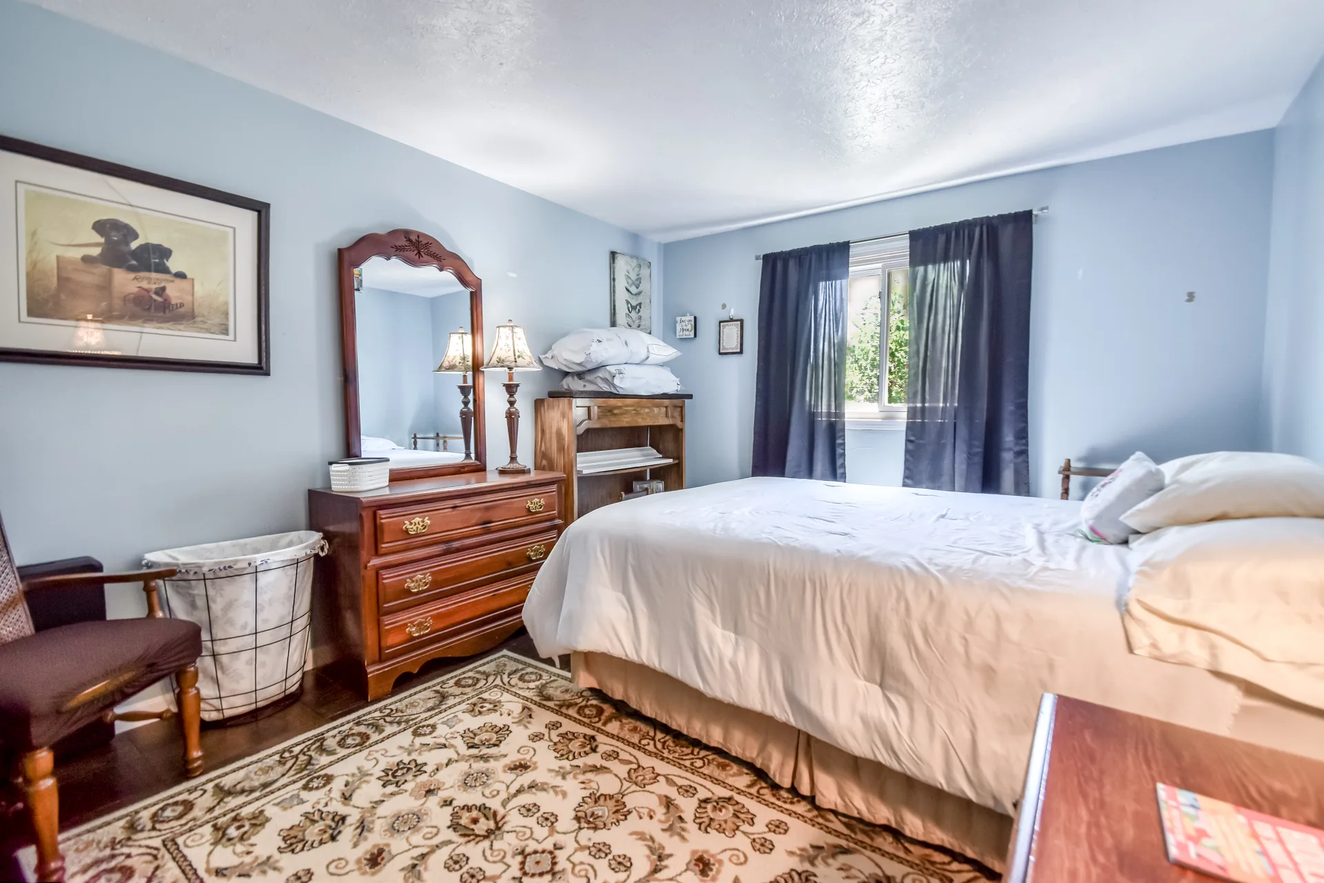 Guest bedroom with light blue walls and wooden furniture