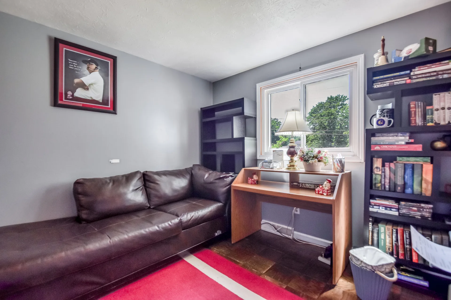 Secondary bedroom used as office with desk and bookshelf