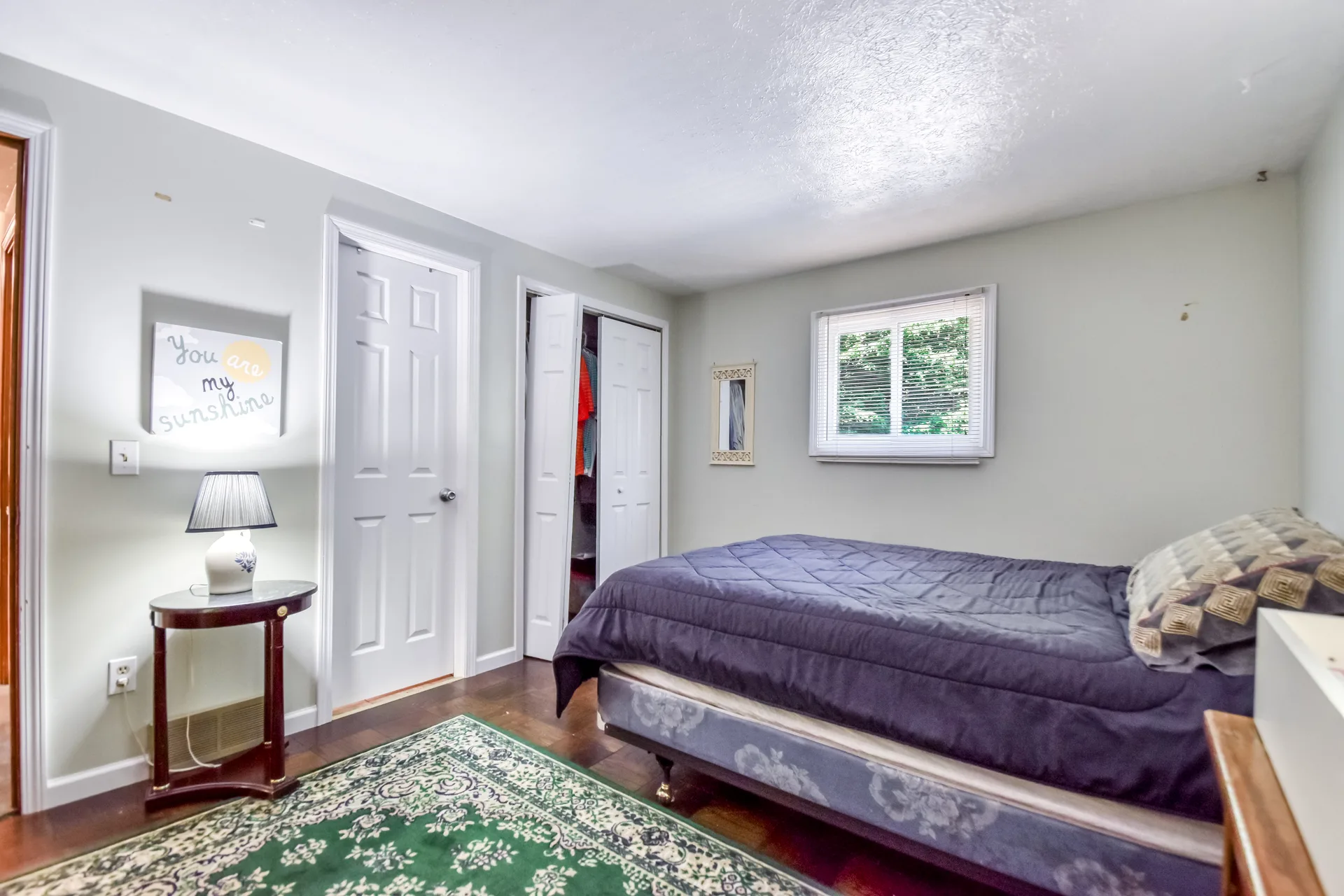 Standard bedroom with hardwood floors and natural light