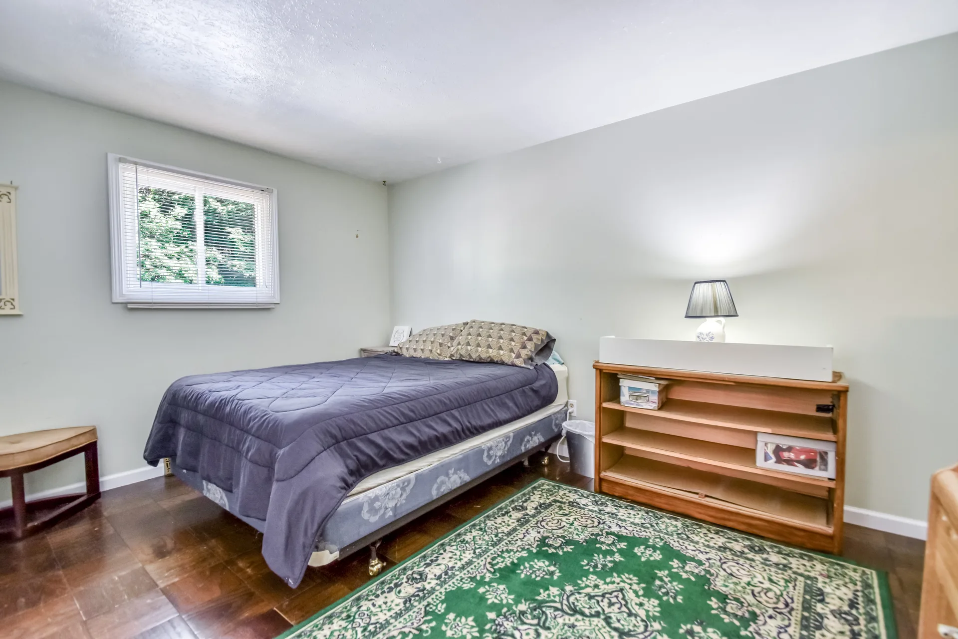 Spare bedroom with hardwood floors and simple furnishings
