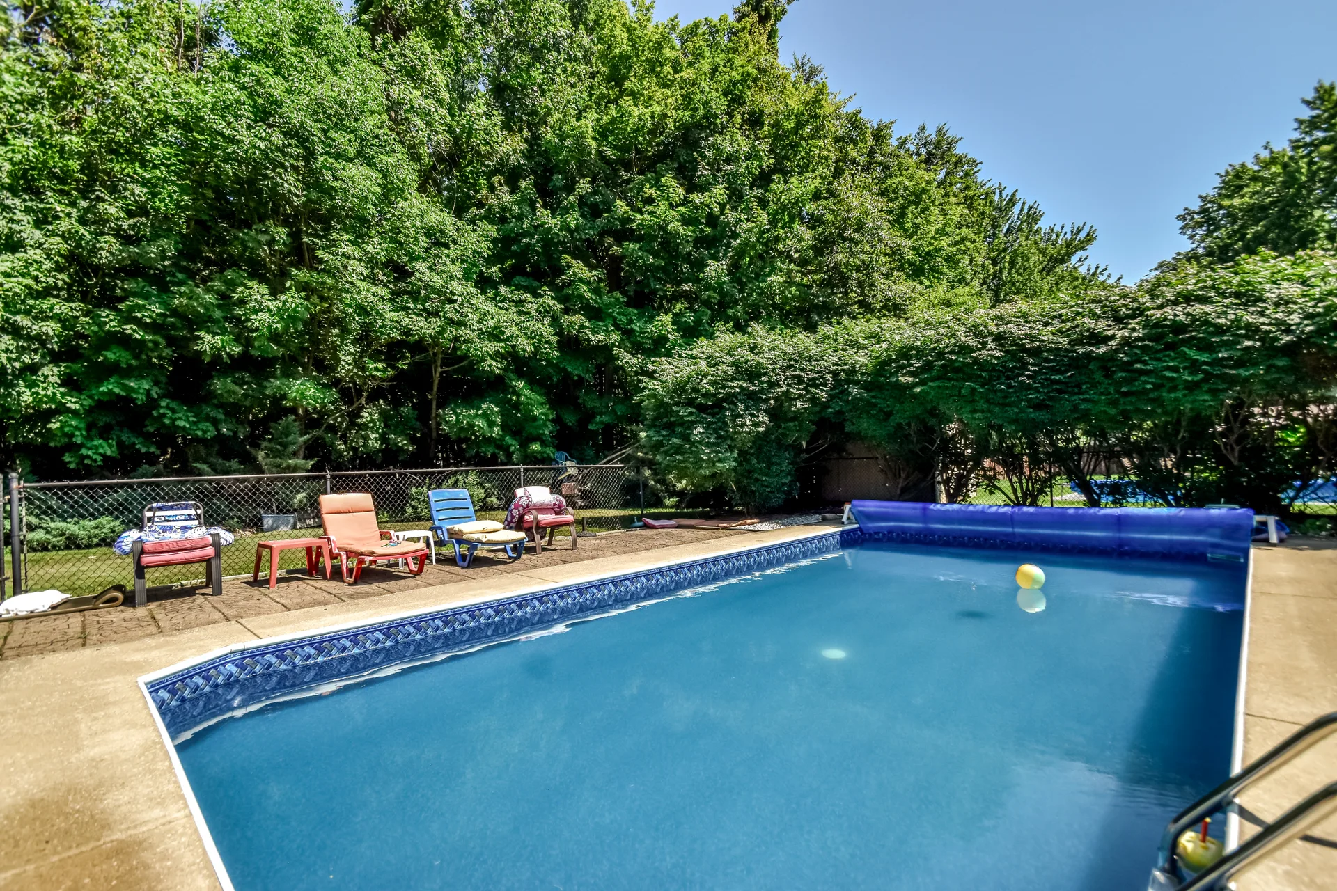 In-ground pool surrounded by mature trees