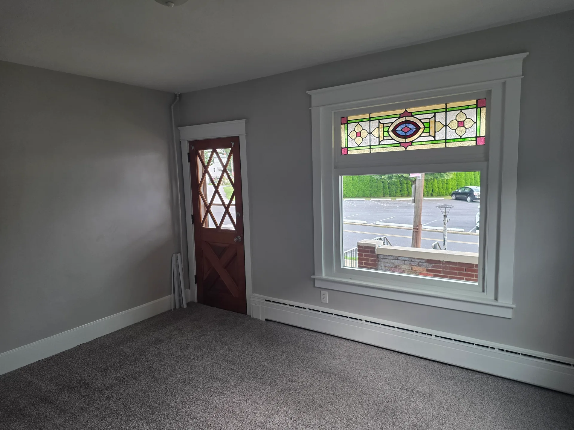 Living room entry with wood door and diamond-pattern window