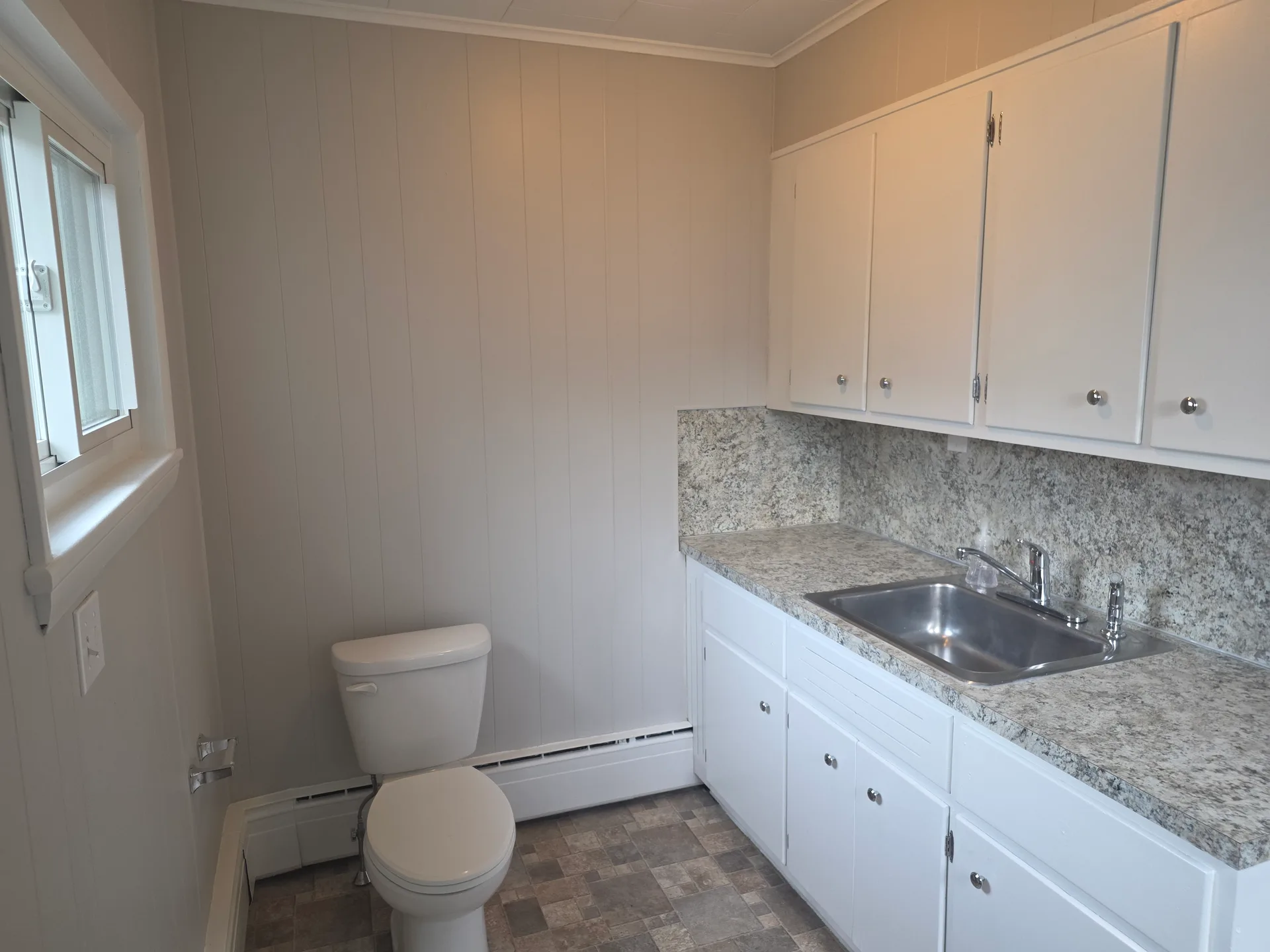 Bathroom and utility area with white cabinetry