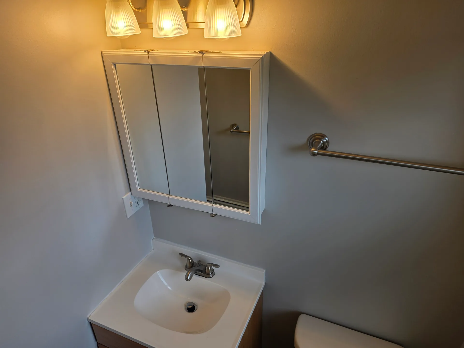 Half bathroom vanity with medicine cabinet and overhead lighting