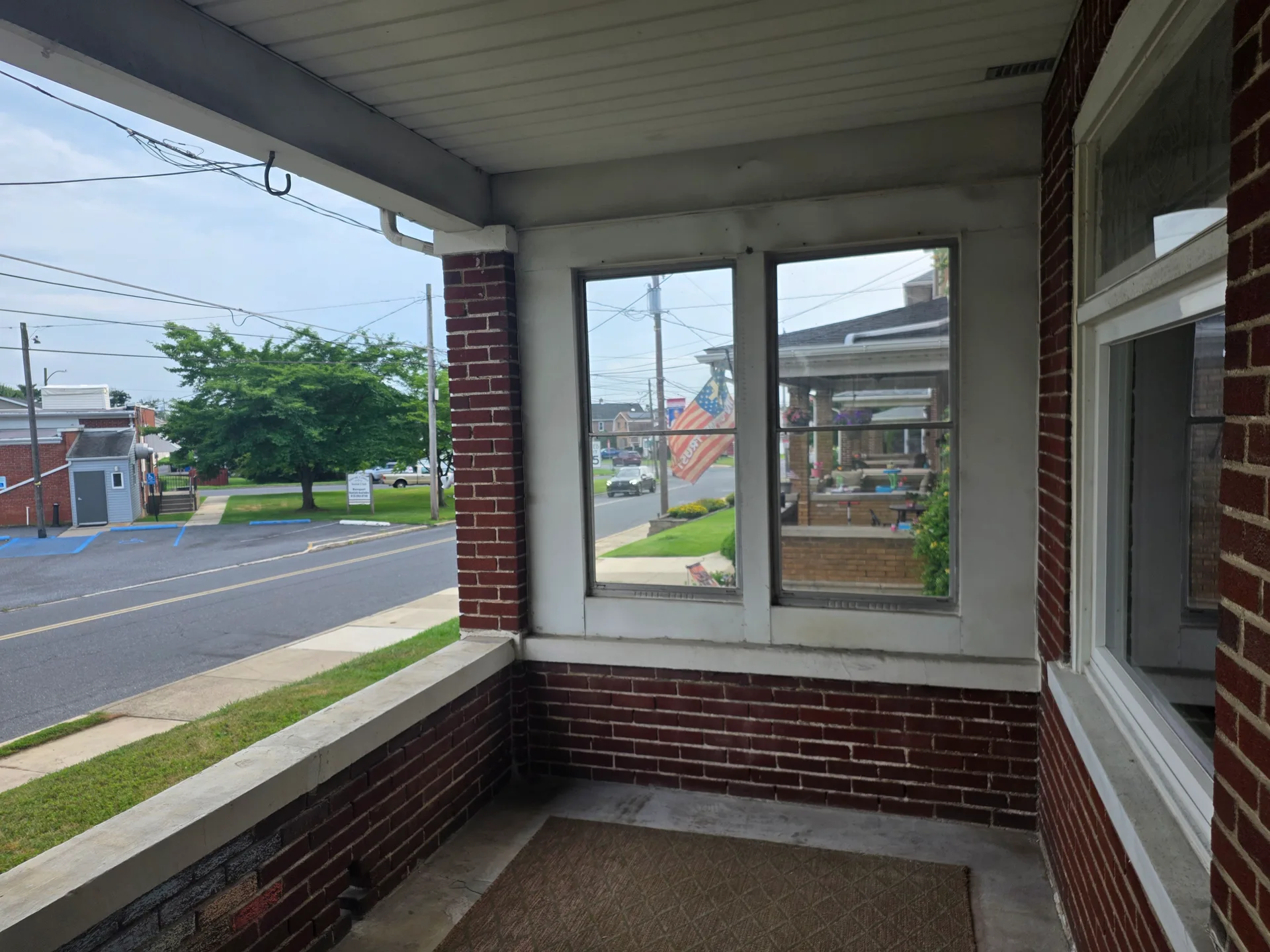Front porch view with brick construction and white trim