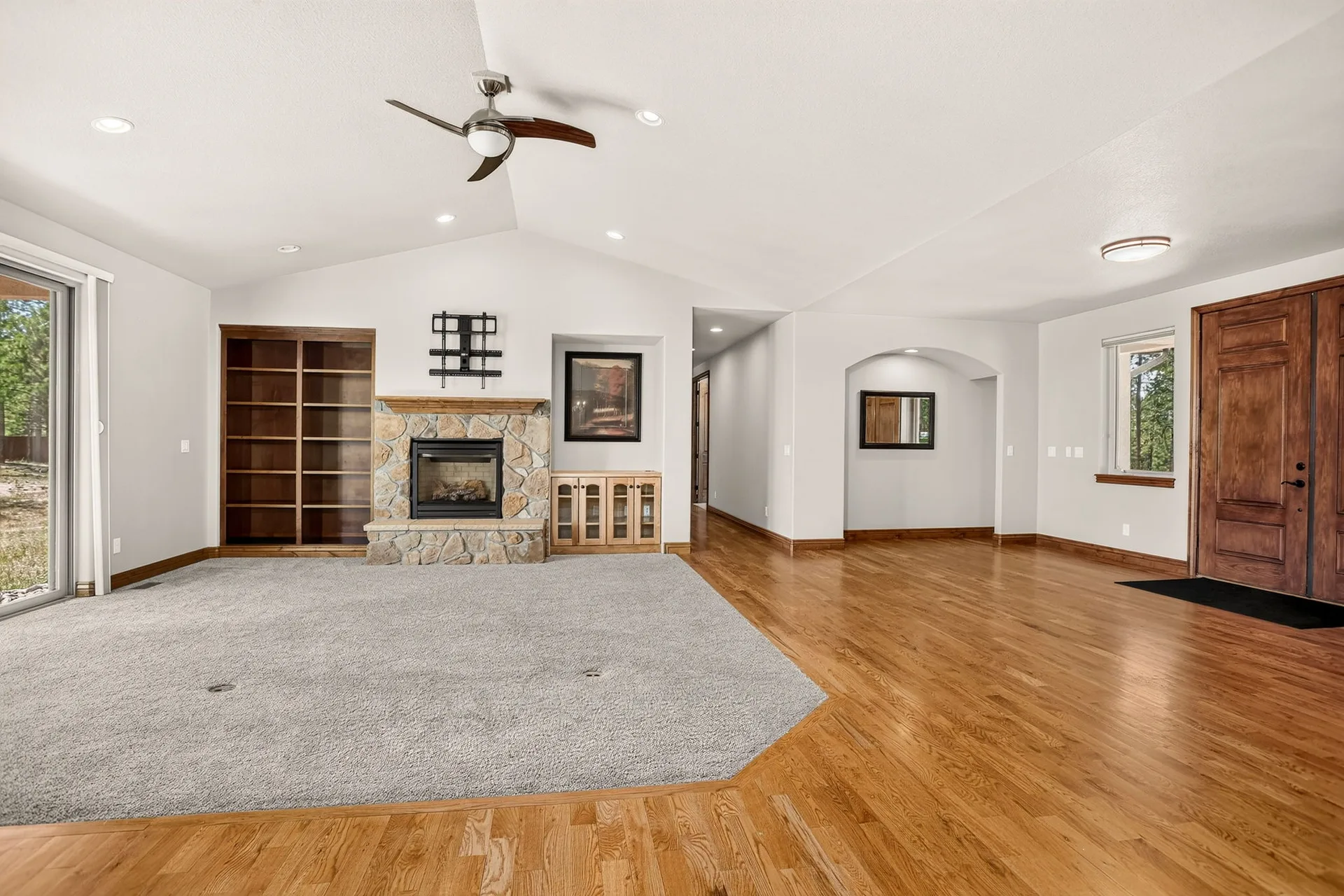Living room with stone fireplace and hardwood floors