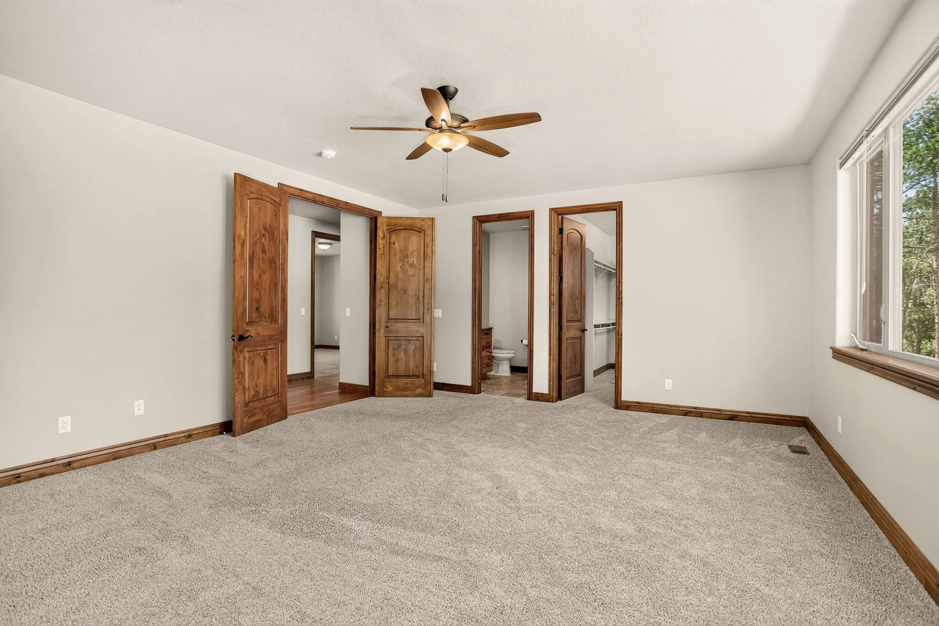 Primary bedroom with natural light and neutral walls