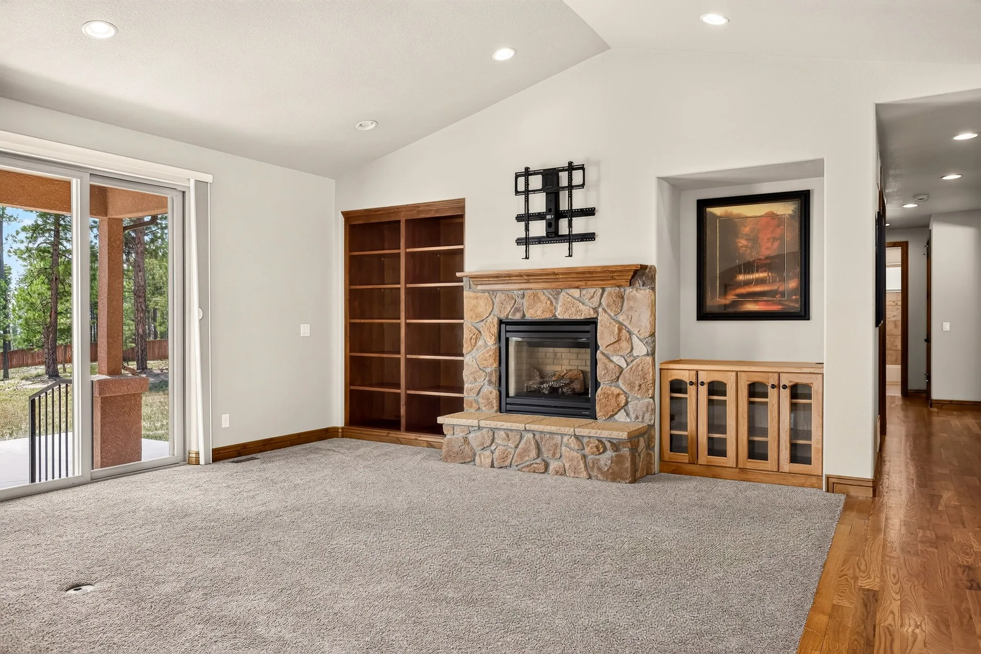 Living room with stone fireplace and carpeted floor
