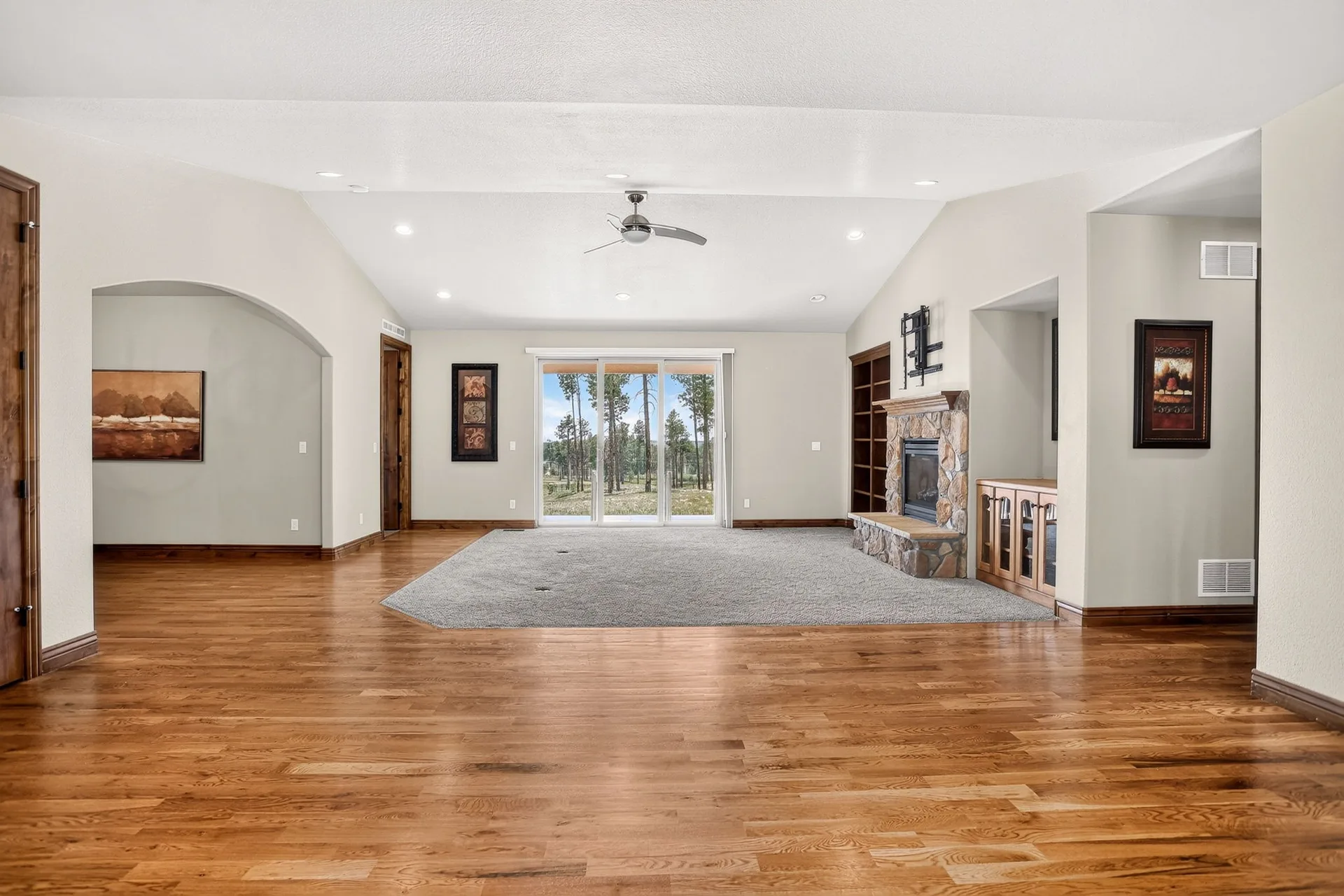 Living room with stone fireplace and built-in shelving