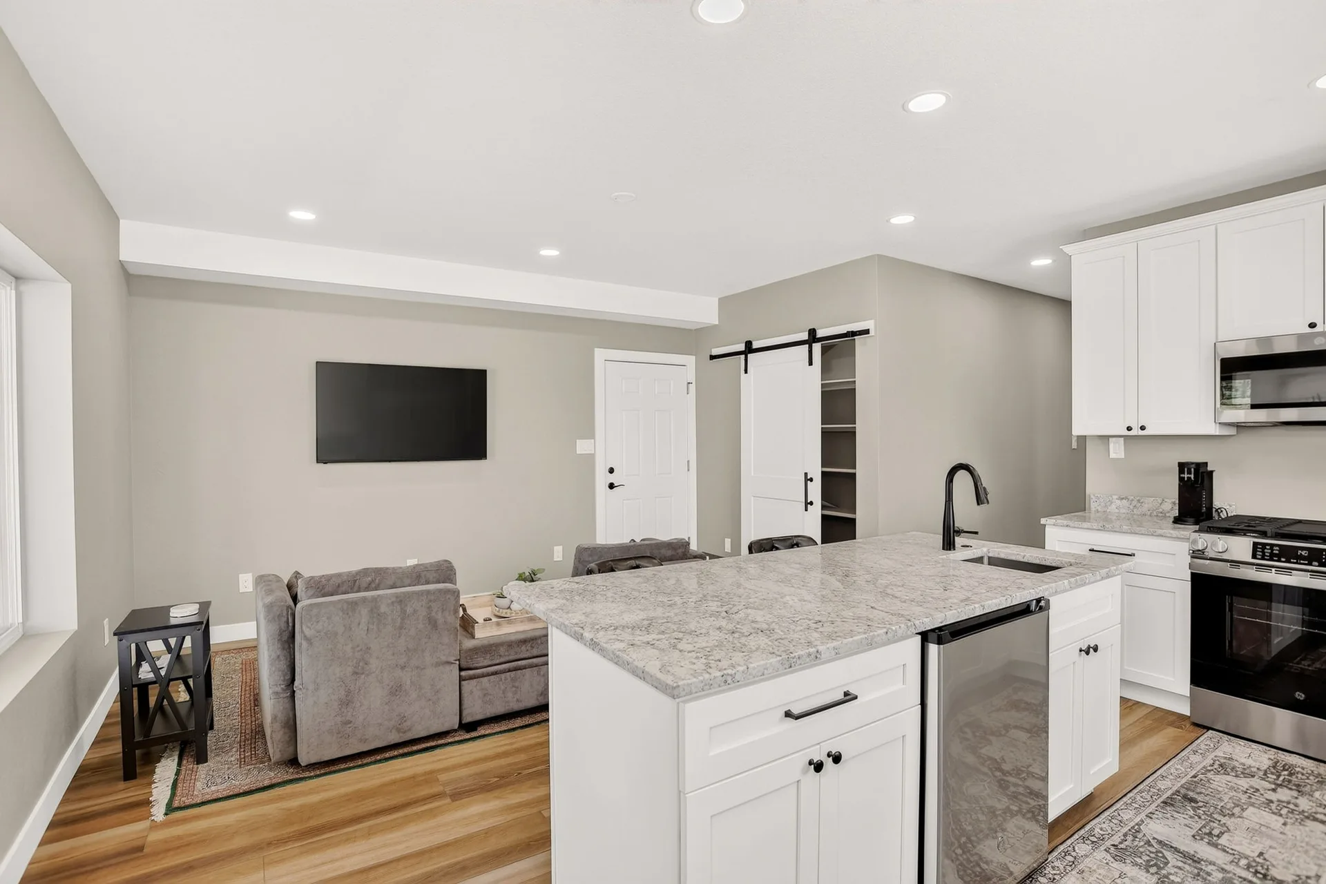 Open-concept kitchen and living area with white cabinets
