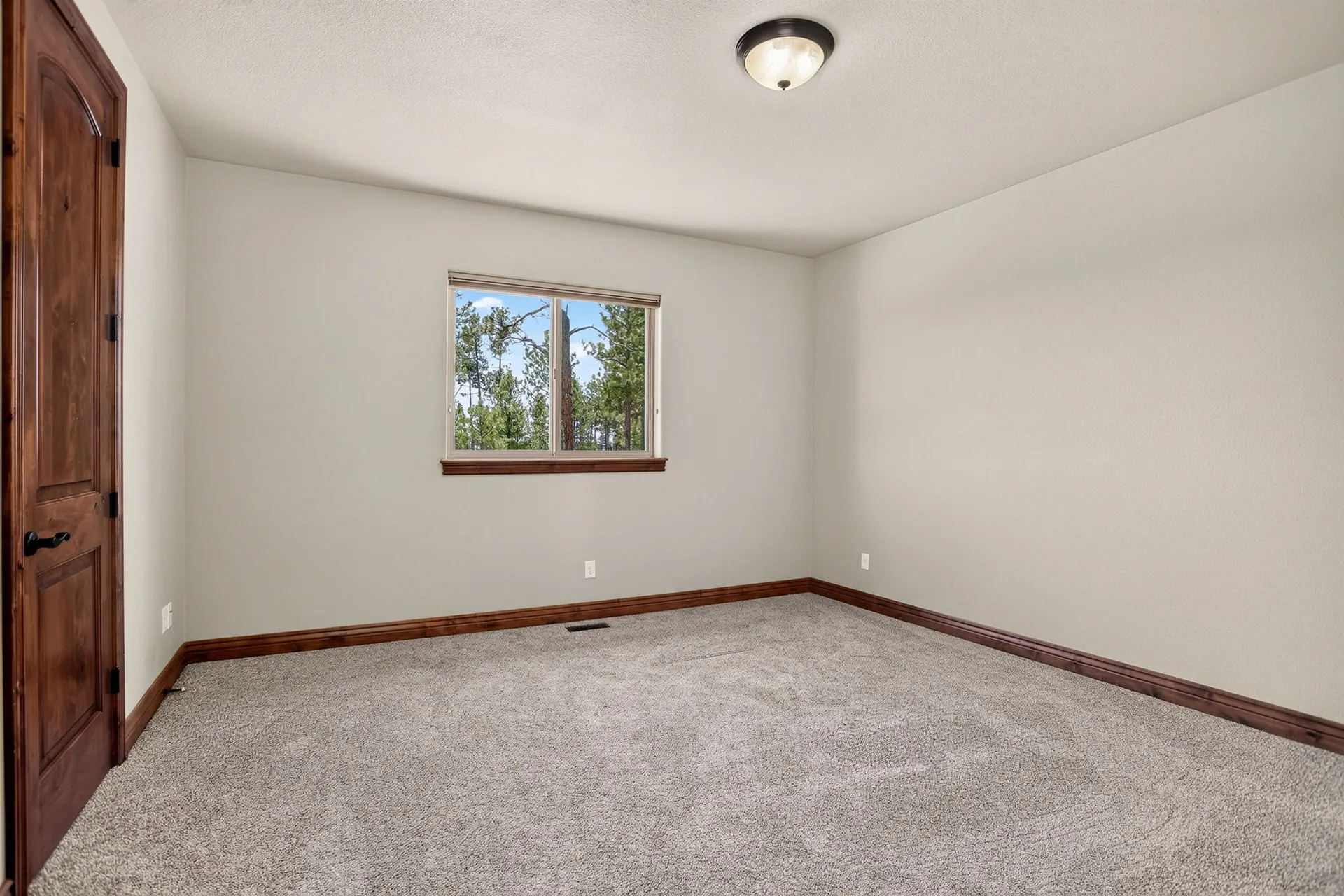 Empty bedroom with wood trim and carpet