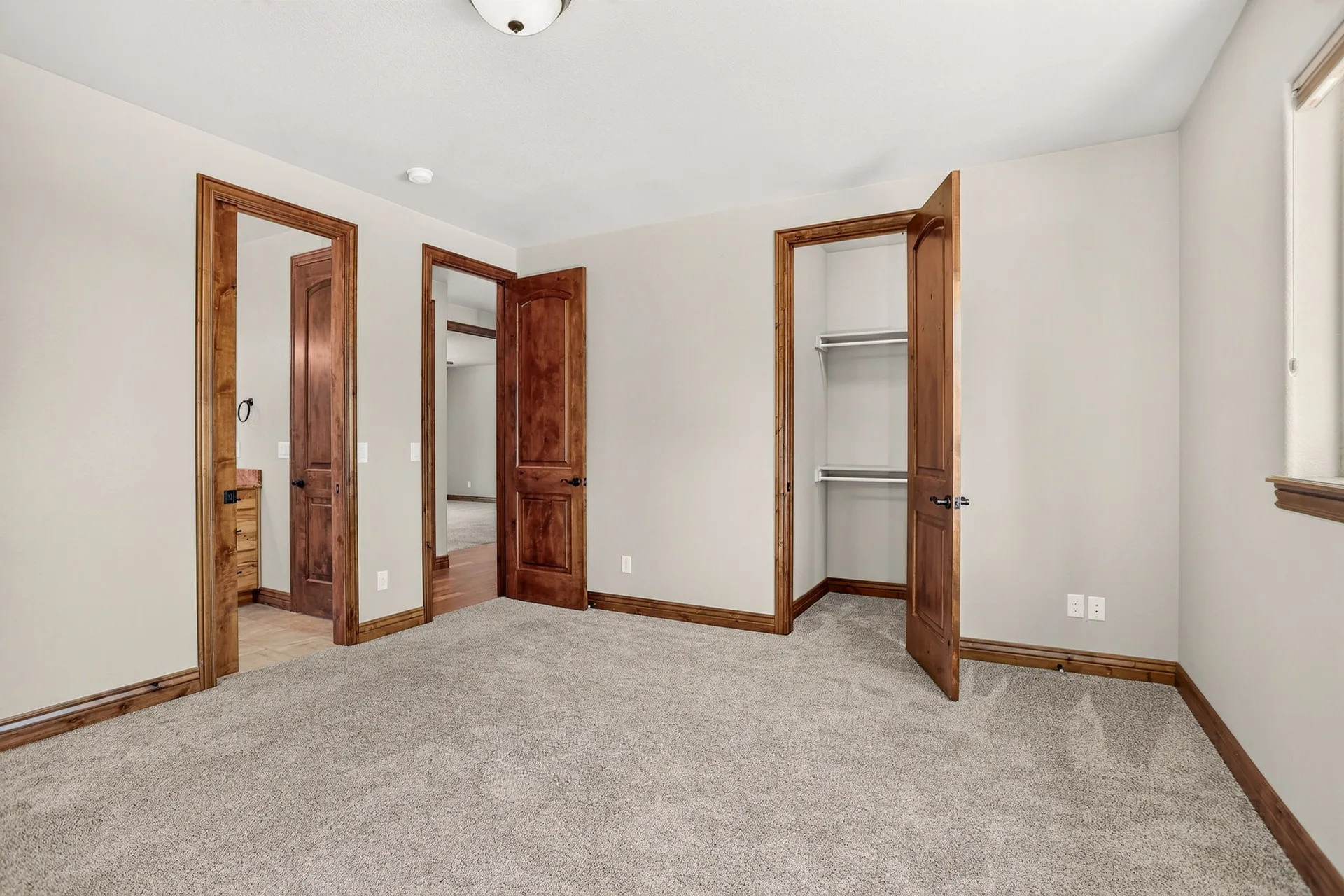 Vacant bedroom with neutral walls and wood trim