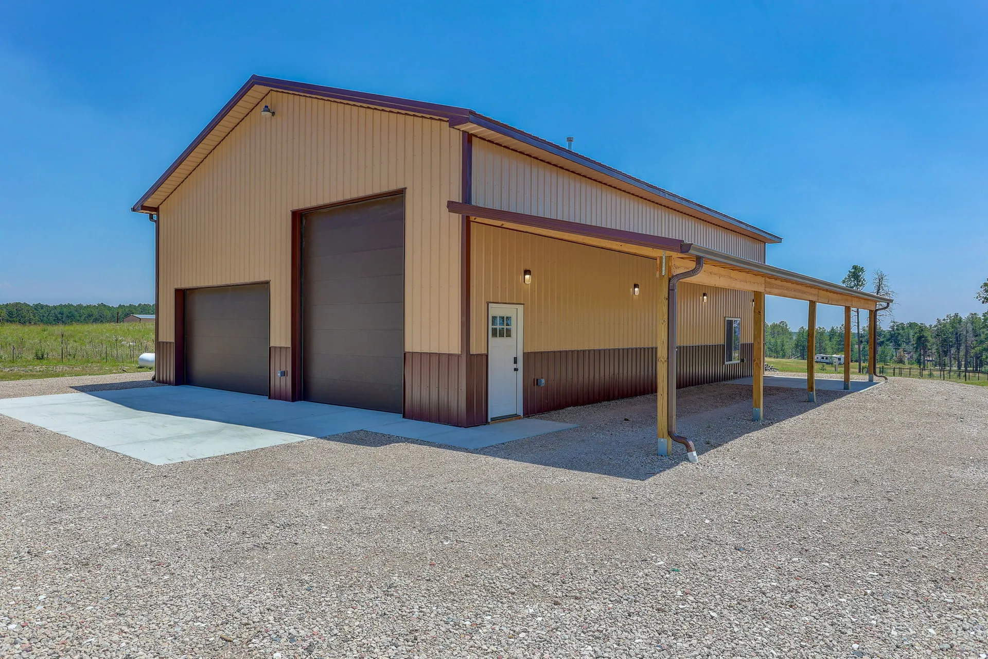Brand-new metal shop building with two-tone siding and covered porch