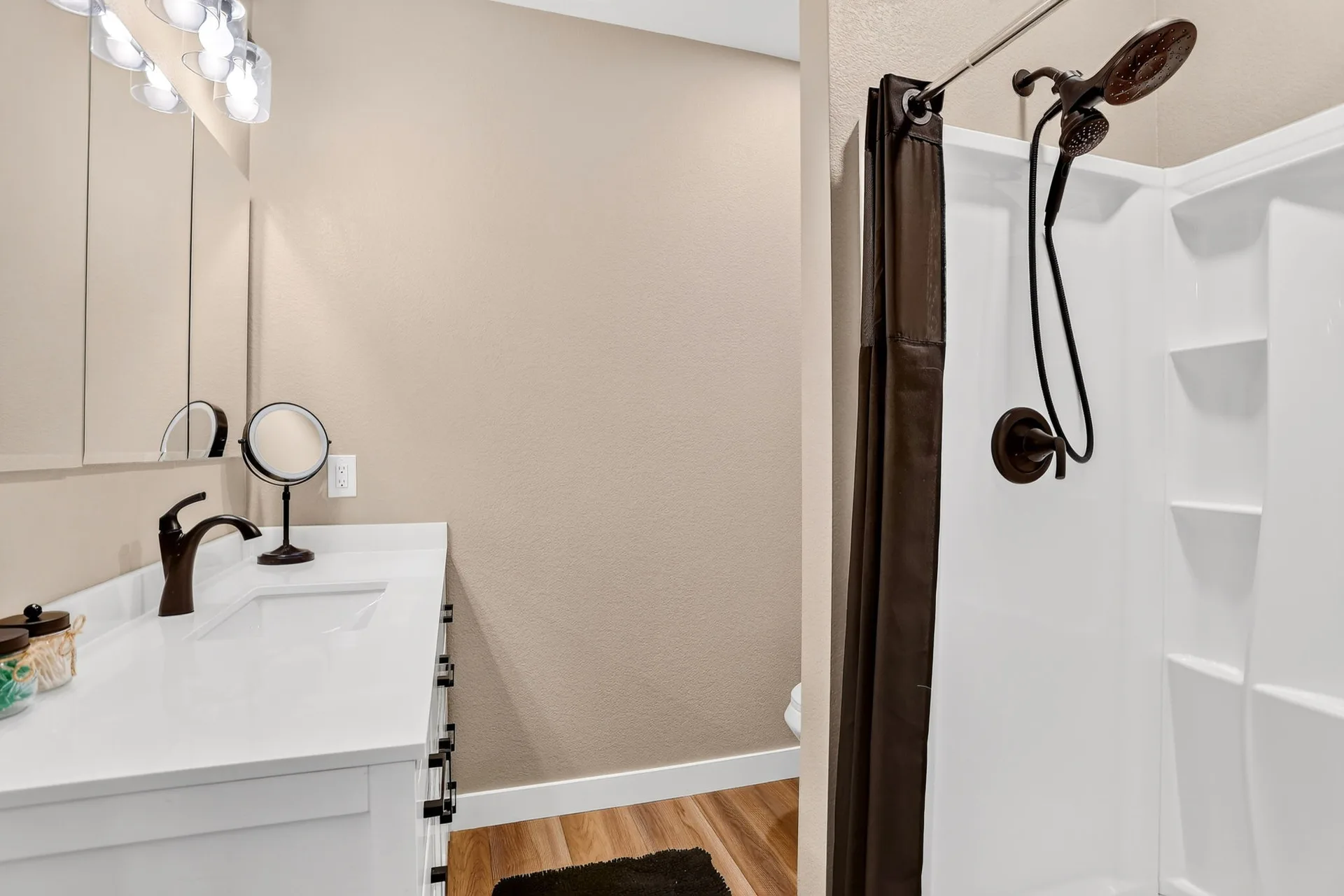 Modern bathroom with white vanity and wood-look flooring
