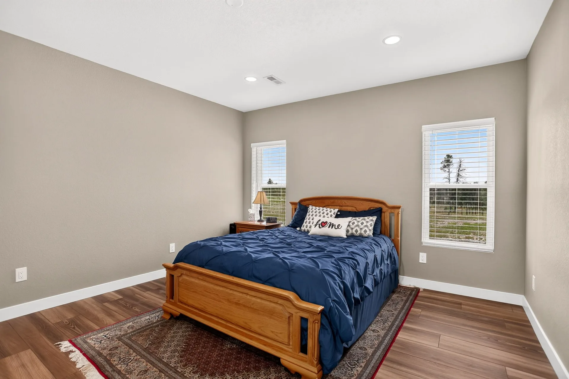 Furnished apartment bedroom with a wooden bed frame and blue bedding