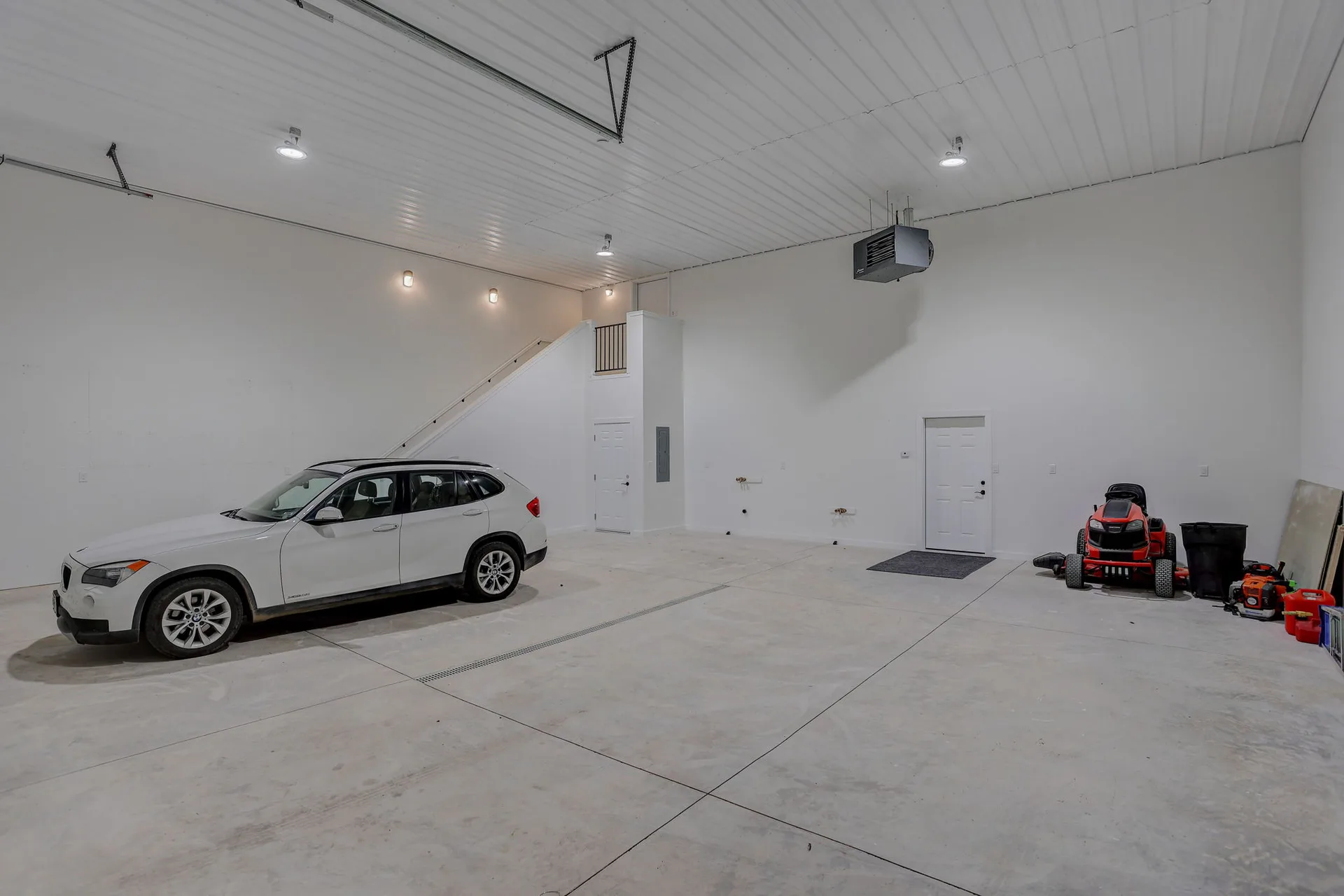 Interior of the fully heated shop with high ceiling, industrial lighting, and room for vehicles and equipment