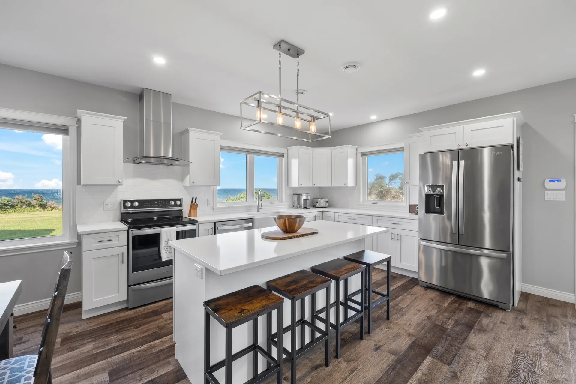 Modern coastal kitchen with white cabinetry and ocean views