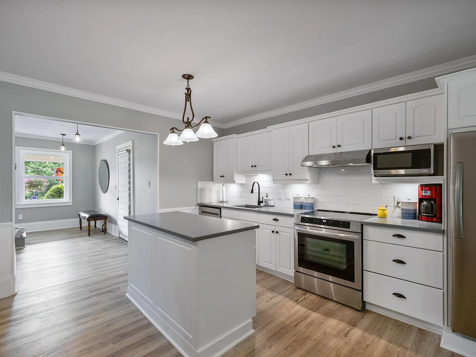 Kitchen with white cabinetry, stainless steel appliances, and grey countertops