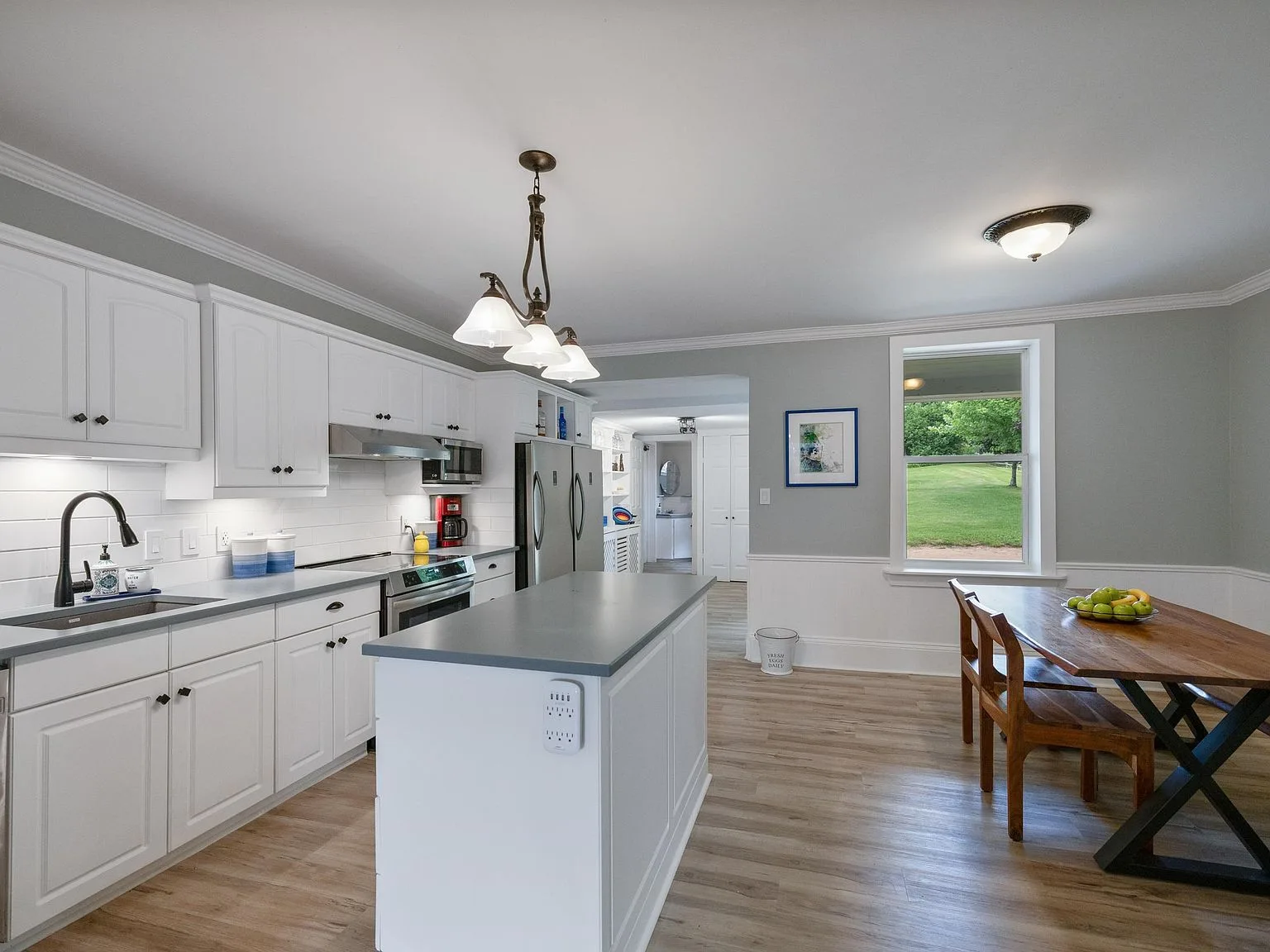 Renovated modern farmhouse kitchen with white cabinetry and grey countertops