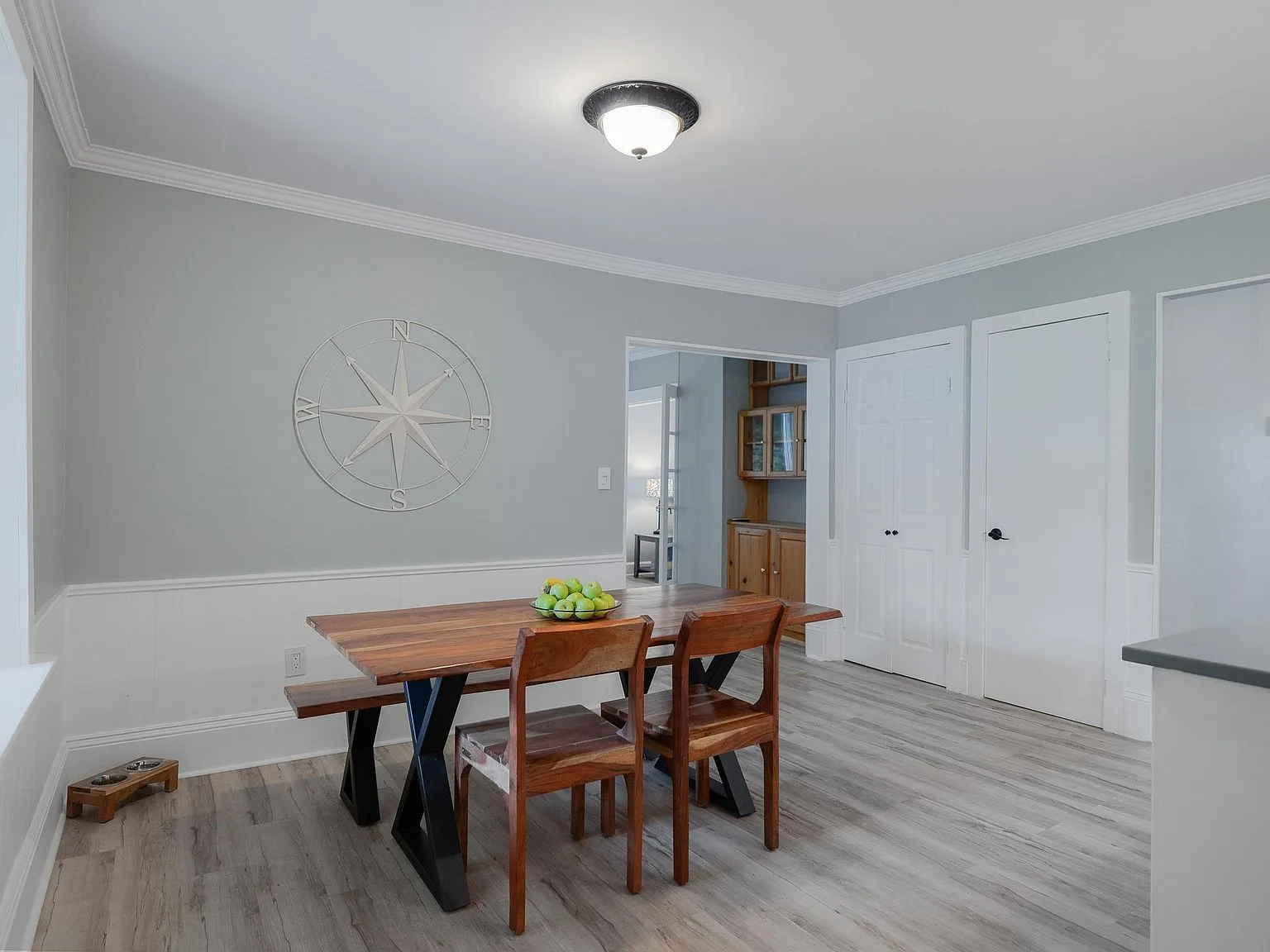 Dining room with light grey walls and white wainscoting