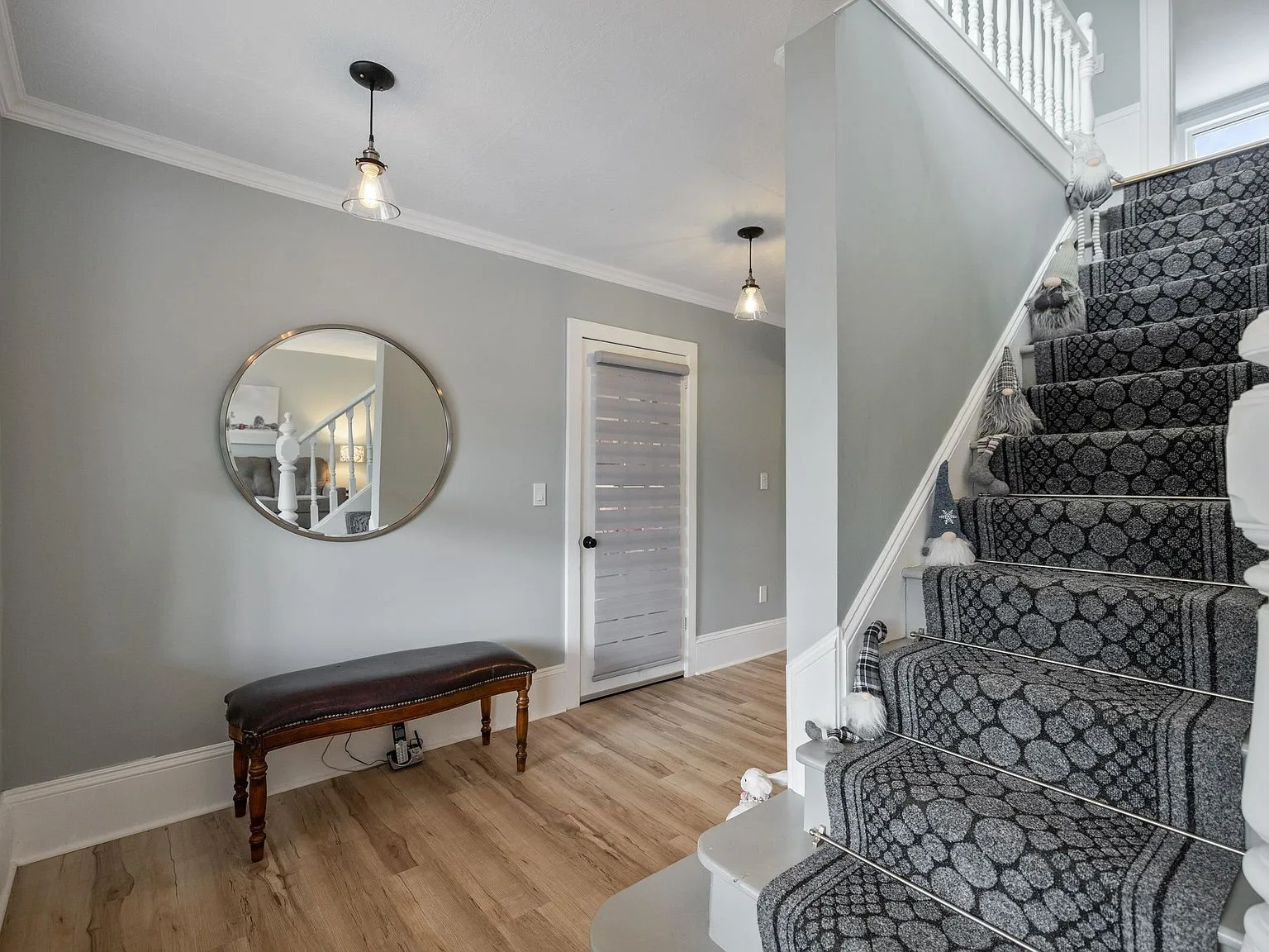 Renovated entryway with modern-farmhouse style staircase, carpeted steps and white balusters