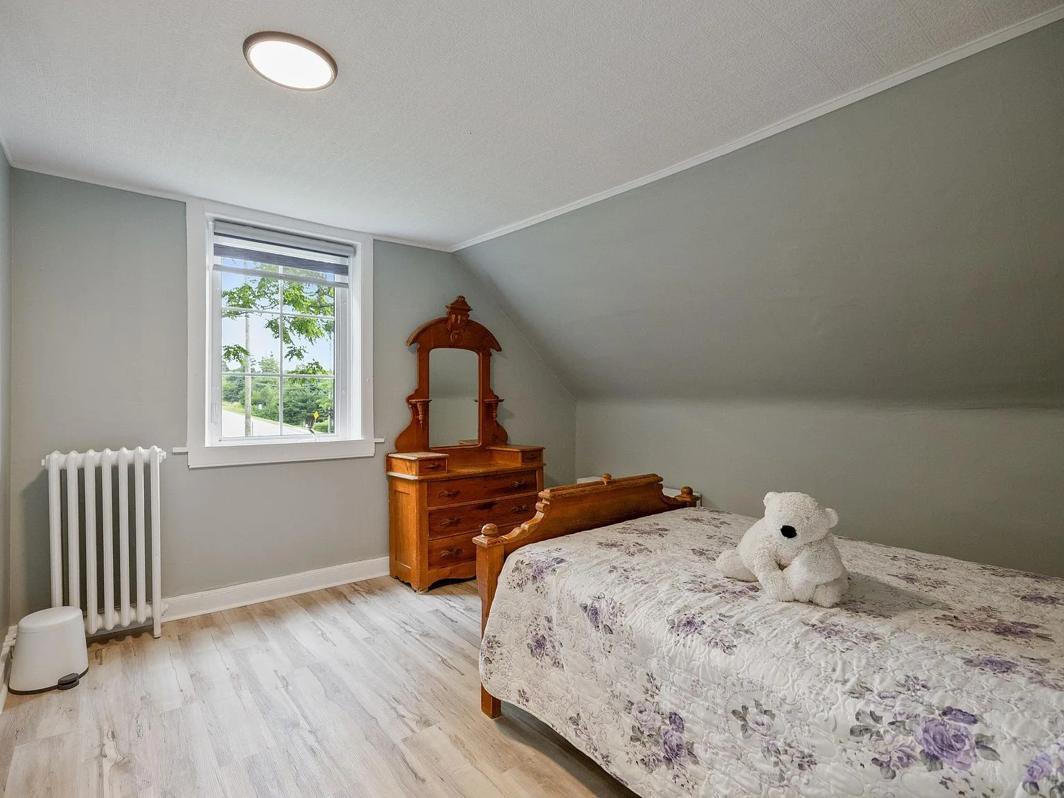 Secondary bedroom with sloped ceiling and light grey walls