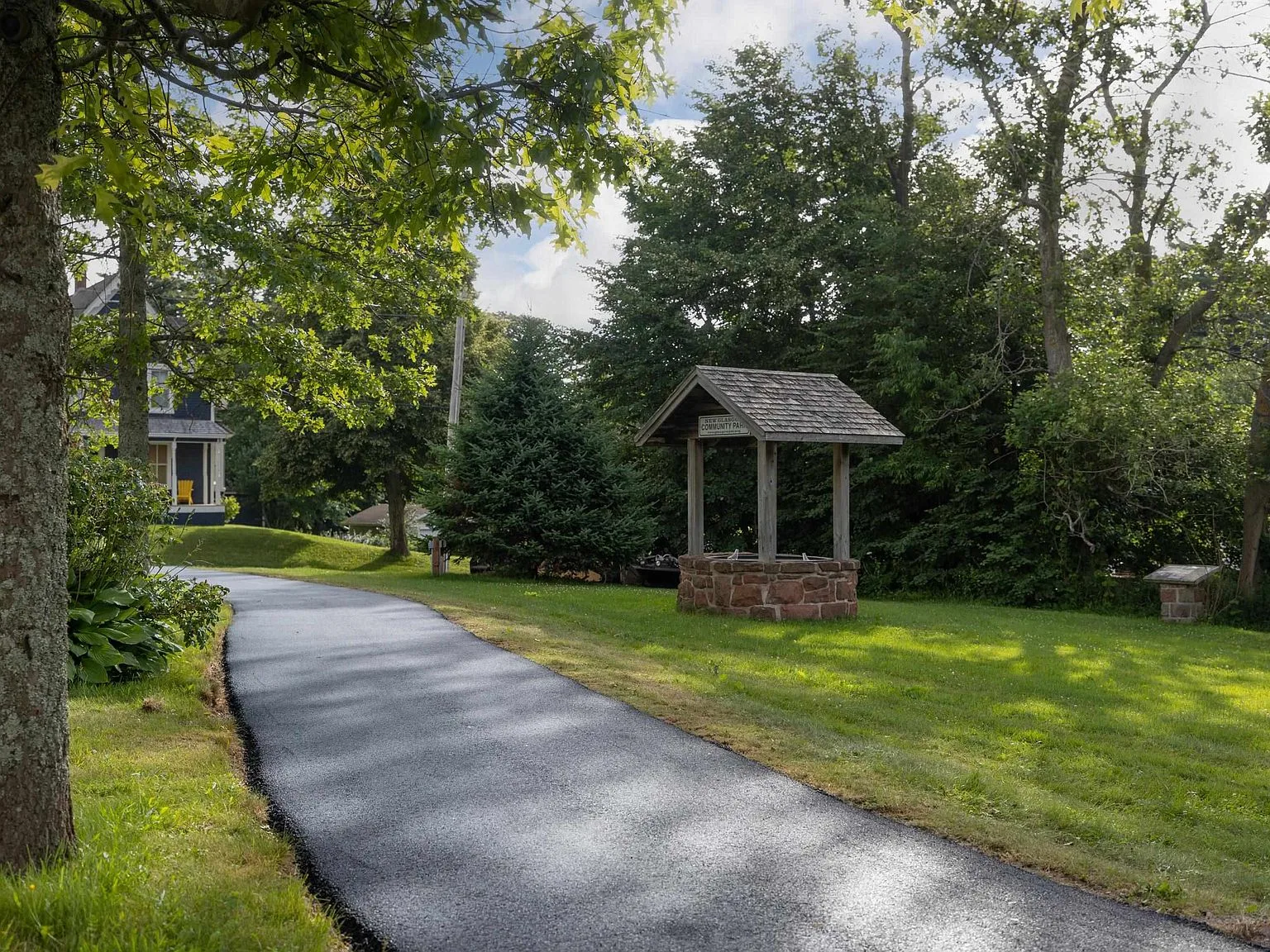 Landscaped backyard with historic stone well and mature trees