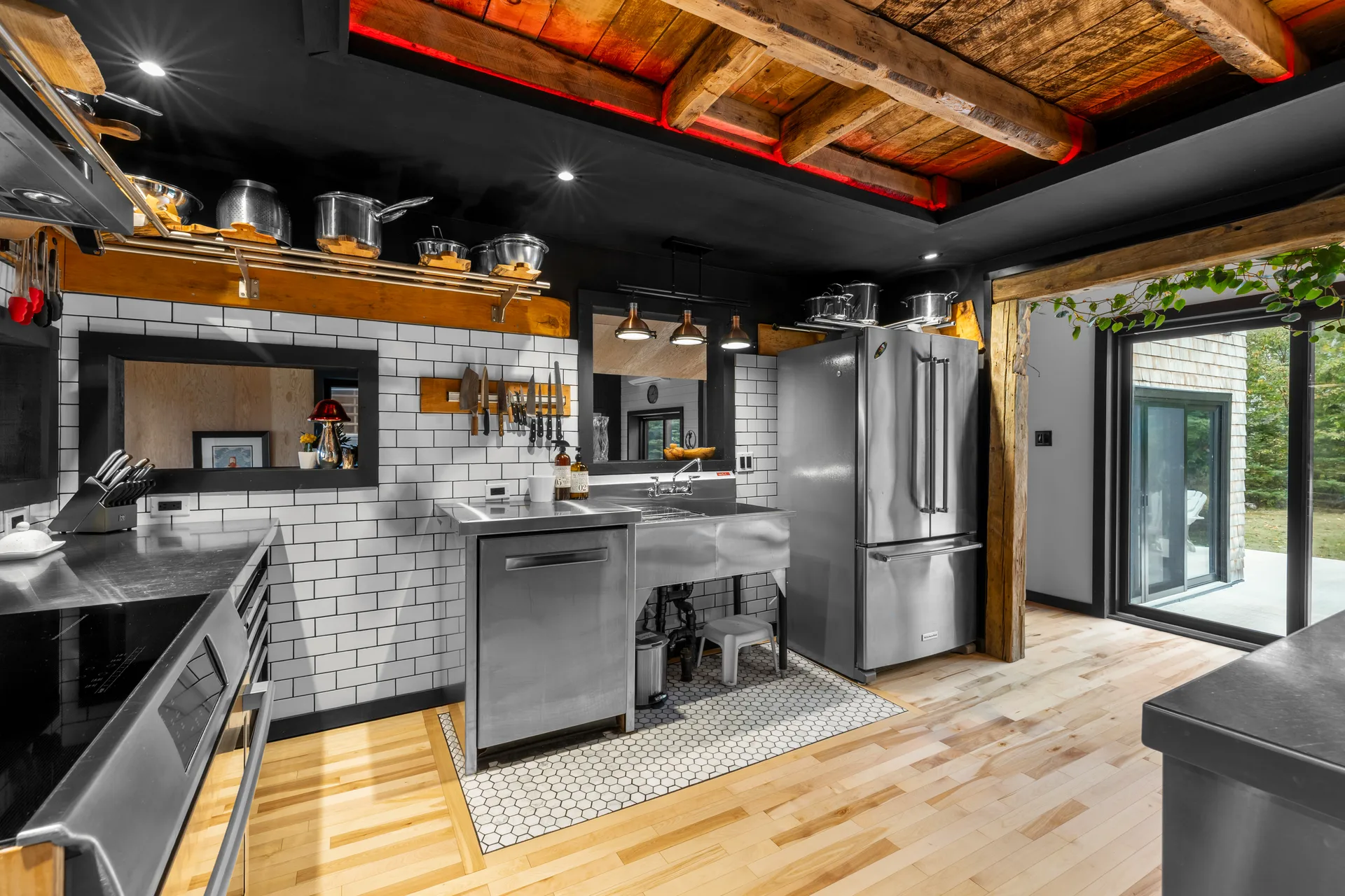 The extraordinary chef's kitchen with industrial farmhouse styling, exposed wood beams, and stainless steel appliances