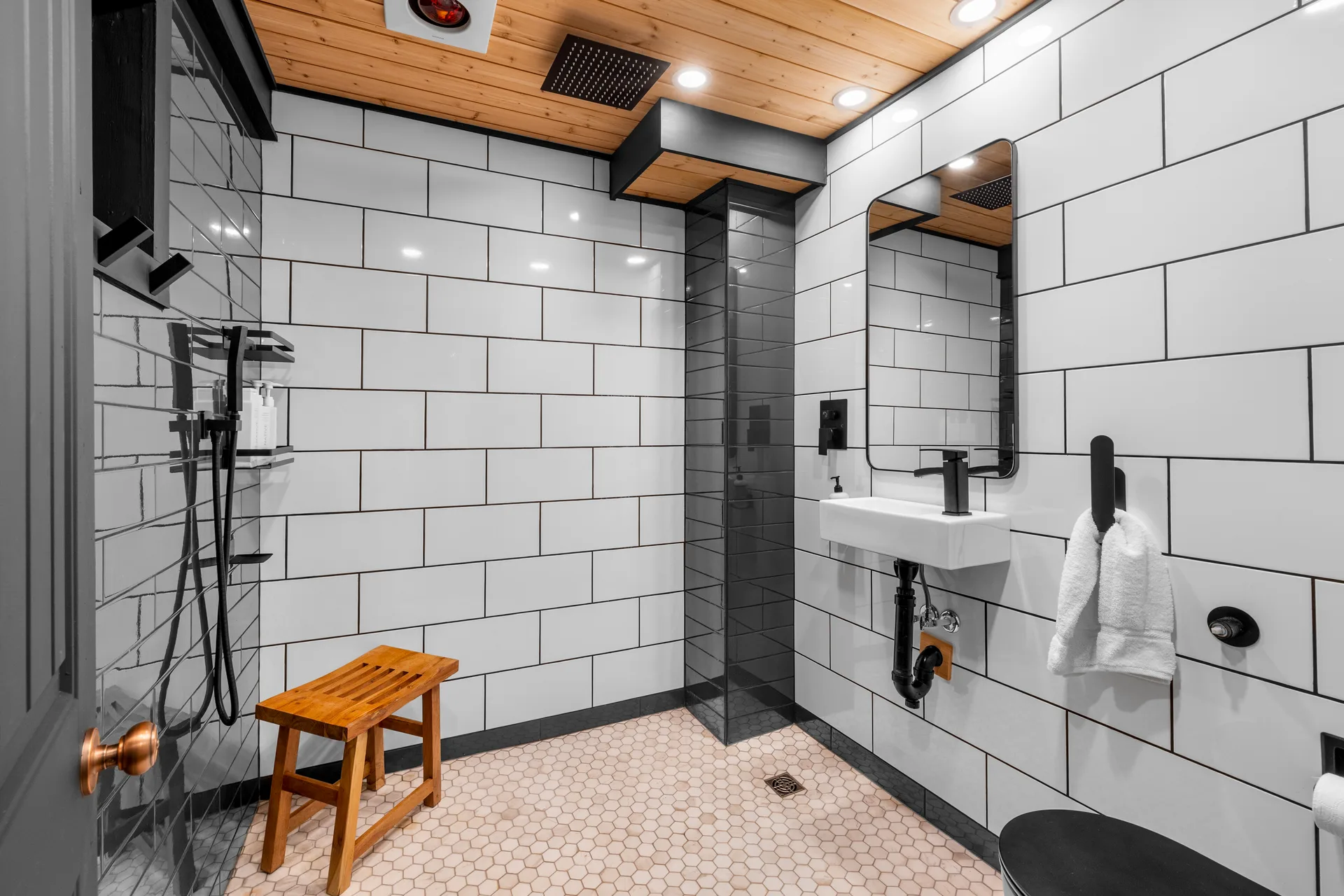Contemporary bathroom with white subway tiles, charcoal grout, wood plank ceiling, and hexagon floor tiles