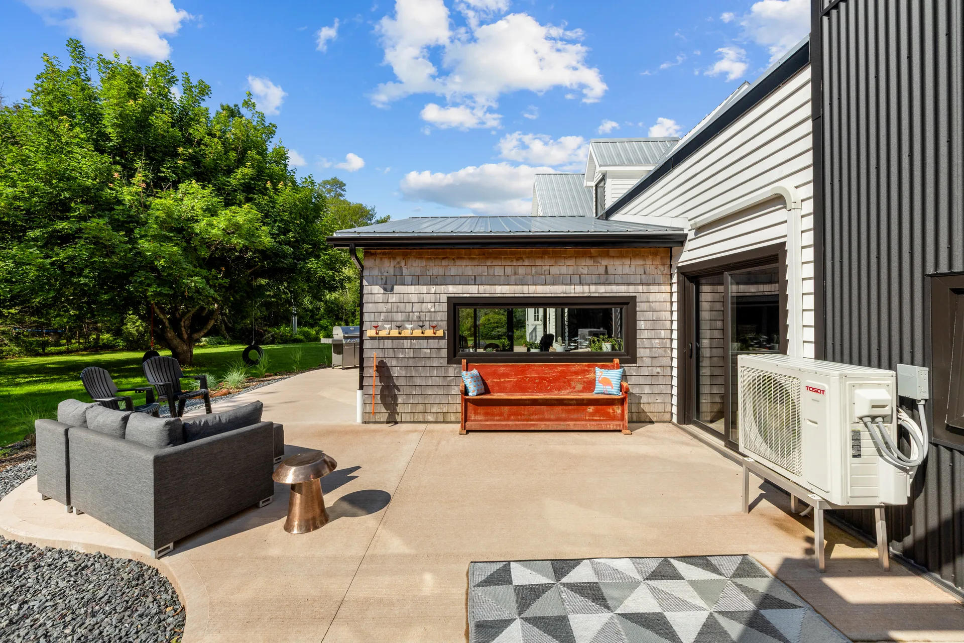 Backyard patio view with cedar shingle siding, metal roof, and modern farmhouse addition