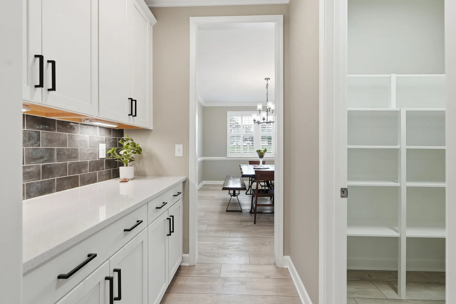Butler's pantry with white cabinets and quartz counters