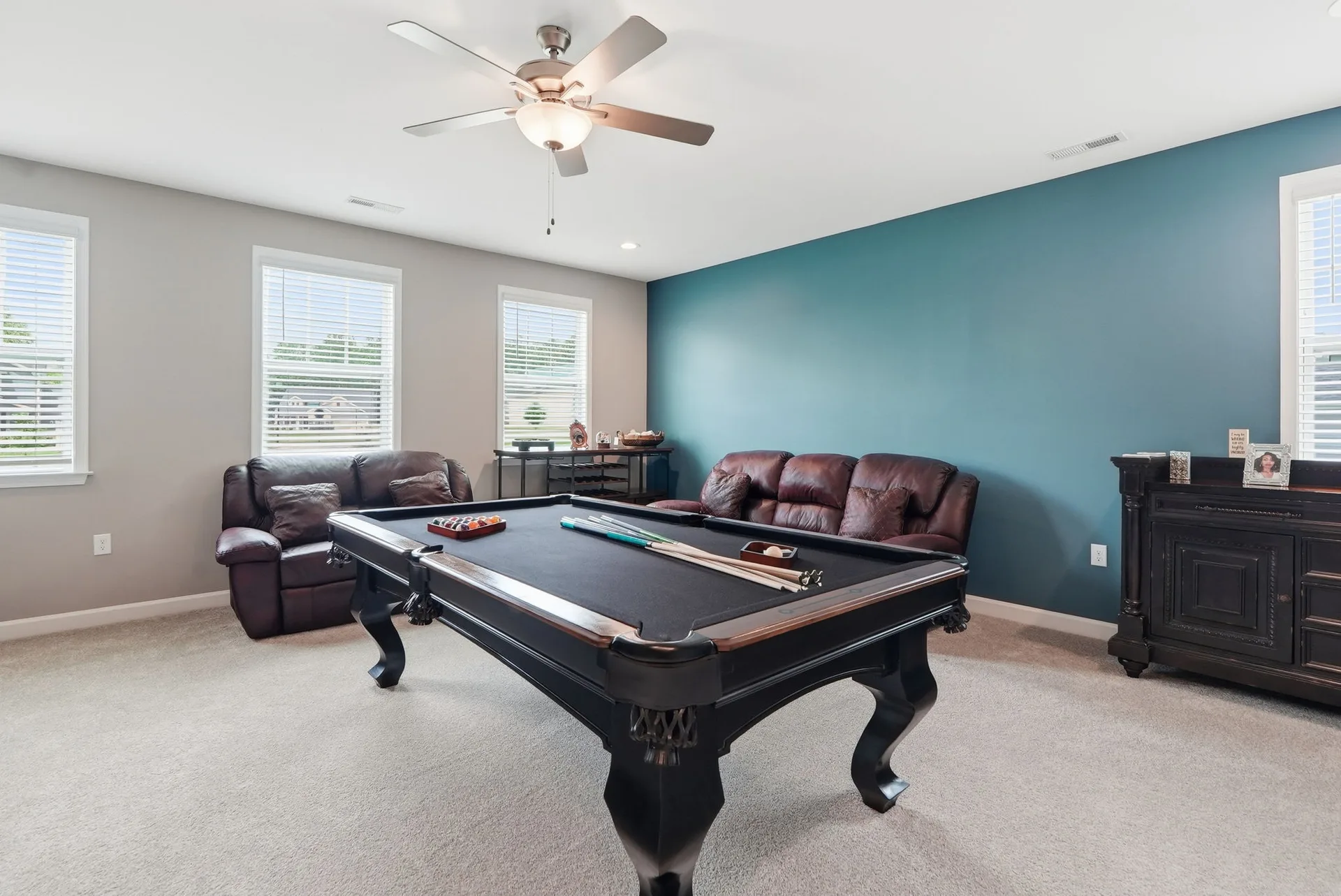 Bonus room with teal accent wall and pool table