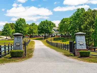 Property entrance with stone pillars and fencing