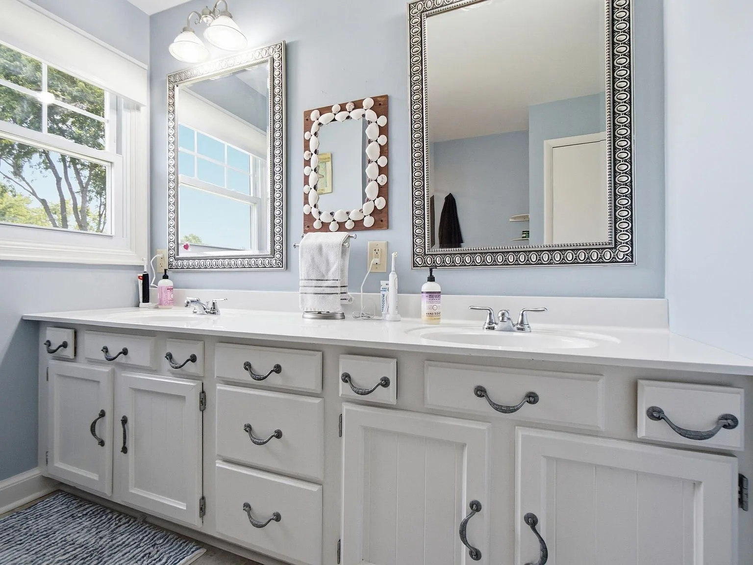 Bathroom with dual-sink white vanity and light blue walls